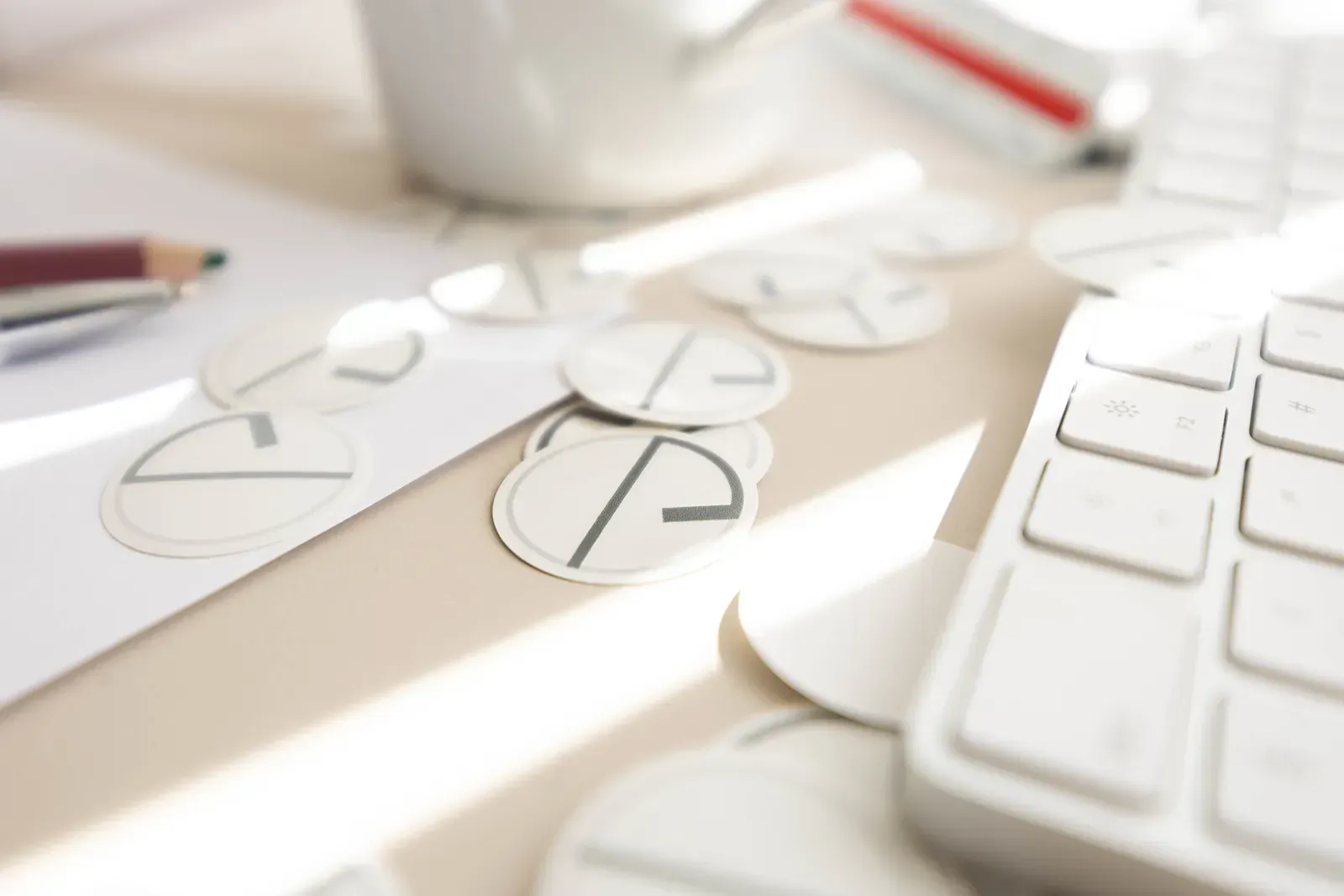 Skrivebordsscene med tastatur, papir, kaffekopp, blyant og Delta Arkitekter AS logo.