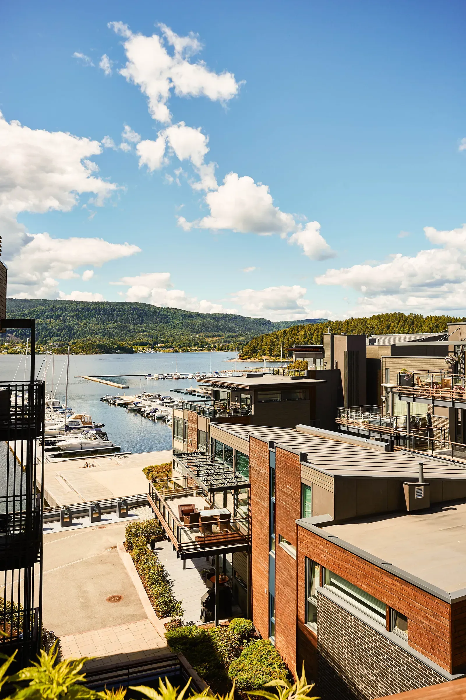 Moderne boligbebyggelse i Nordre Jarlsberg Brygge med varierte volumer, tegl og tre, store vinduer og terrasser mot fjorden
