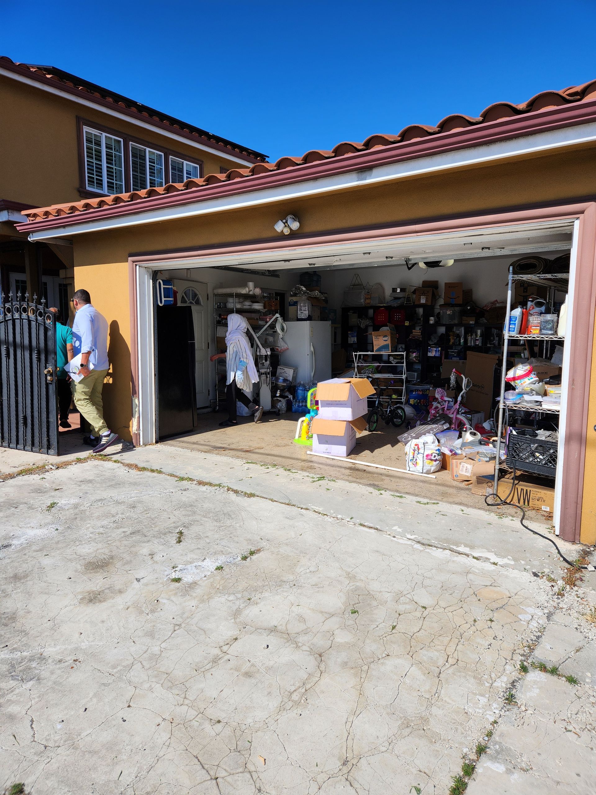 A man is walking into a garage filled with lots of stuff.