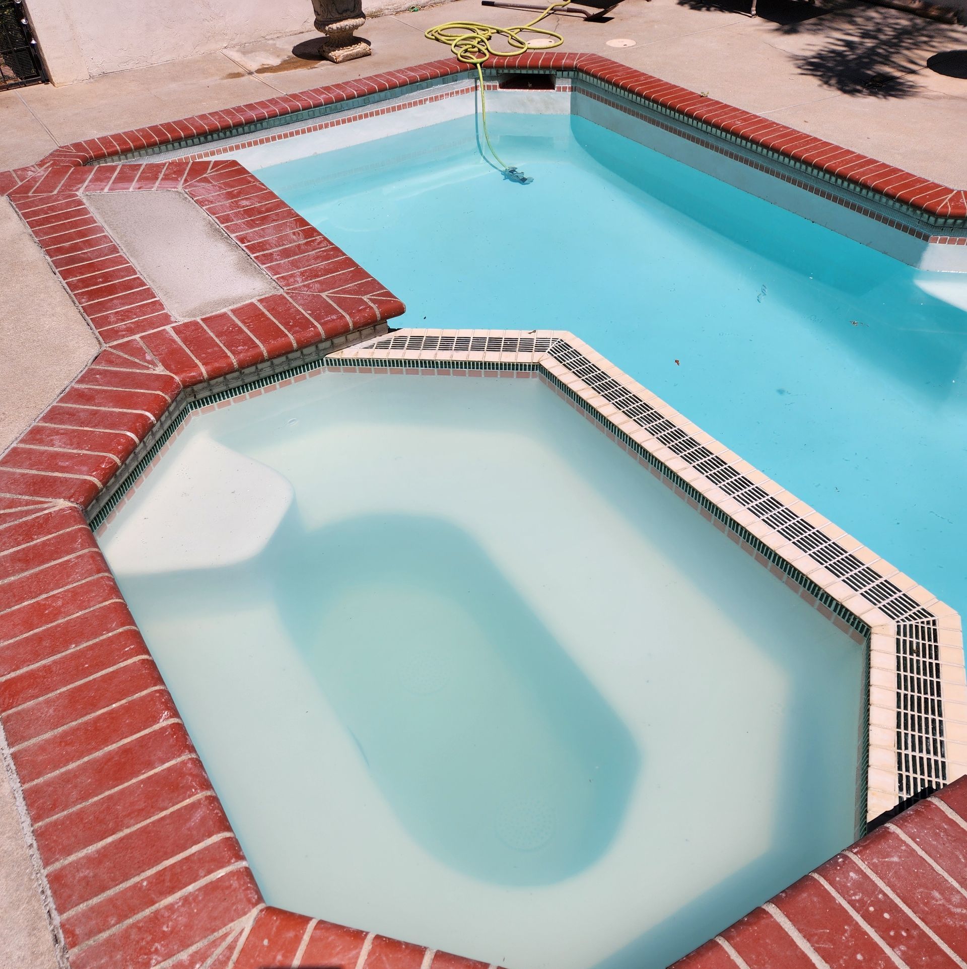 A swimming pool with a hot tub in the middle
