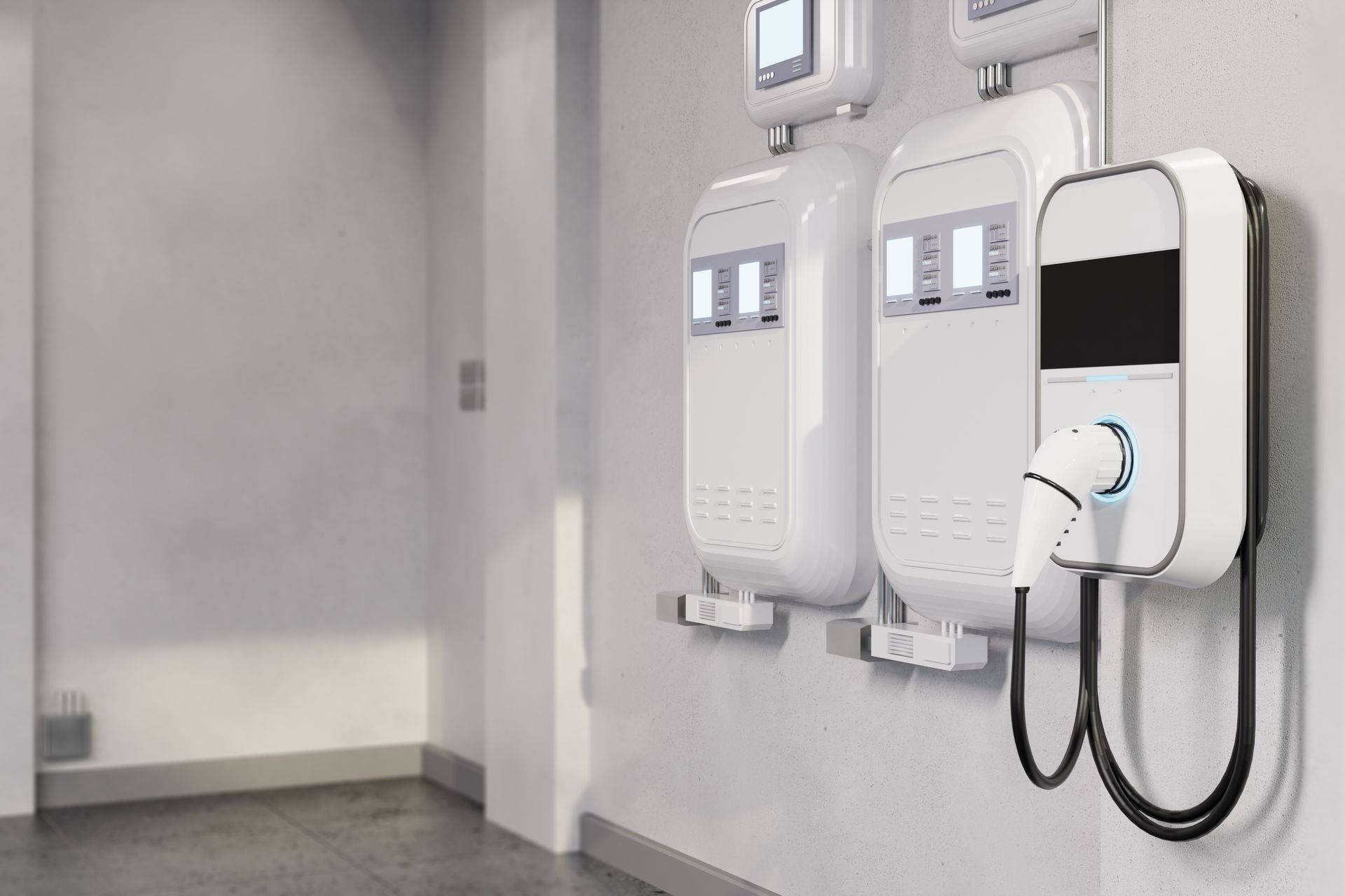 Electric vehicle charging stations mounted on a white wall in a building.