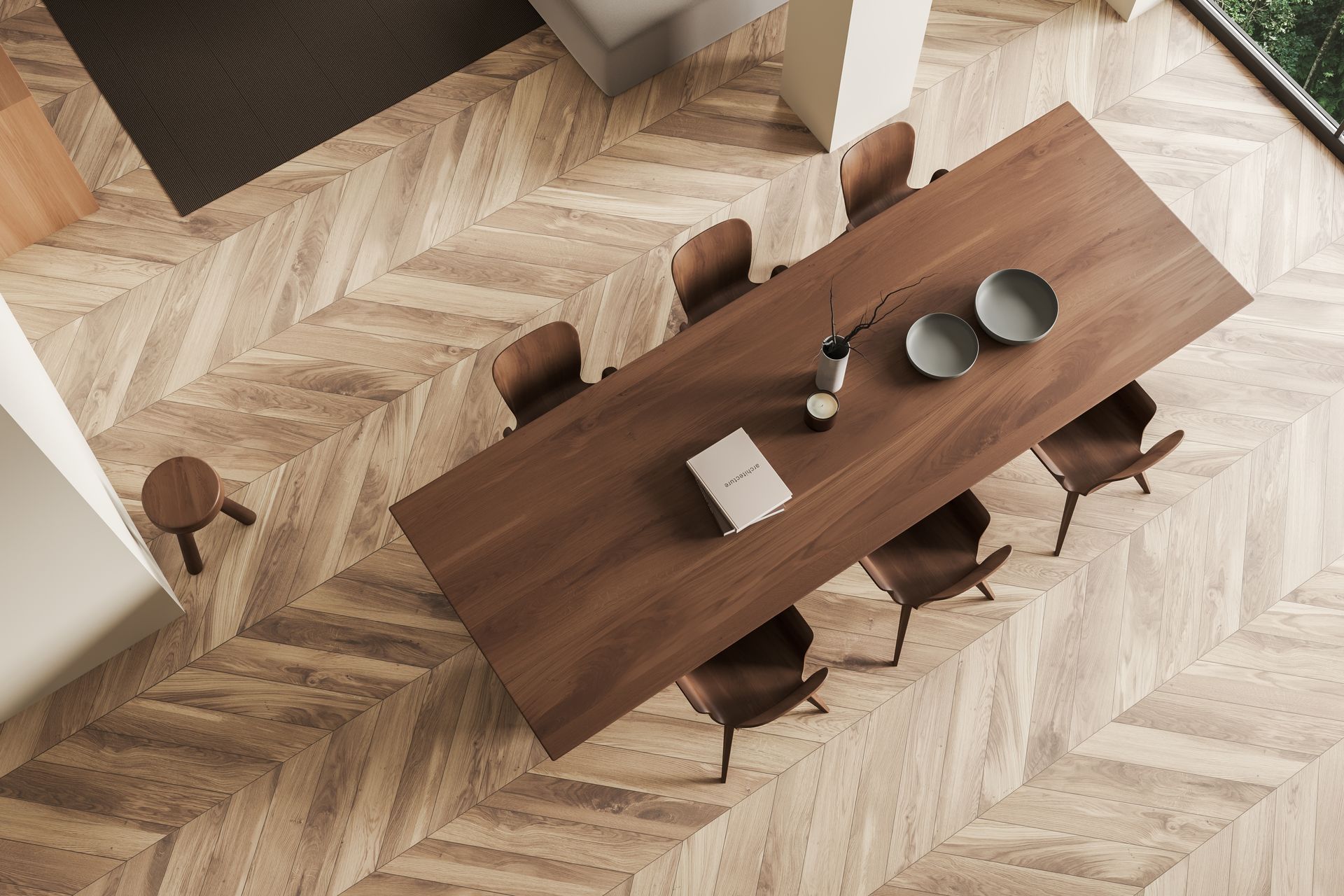 High-angle view of a dining room with a long wooden table set for a meal, surrounded by chairs.