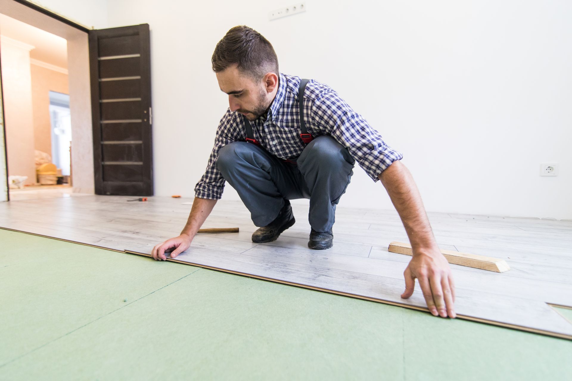 A man is kneeling down on the floor in a room.