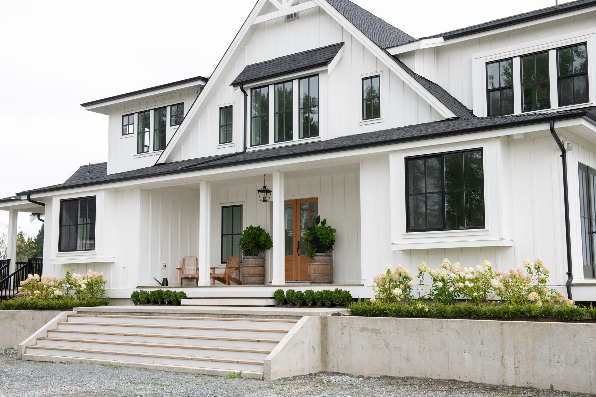 A large white house with black windows and a porch.