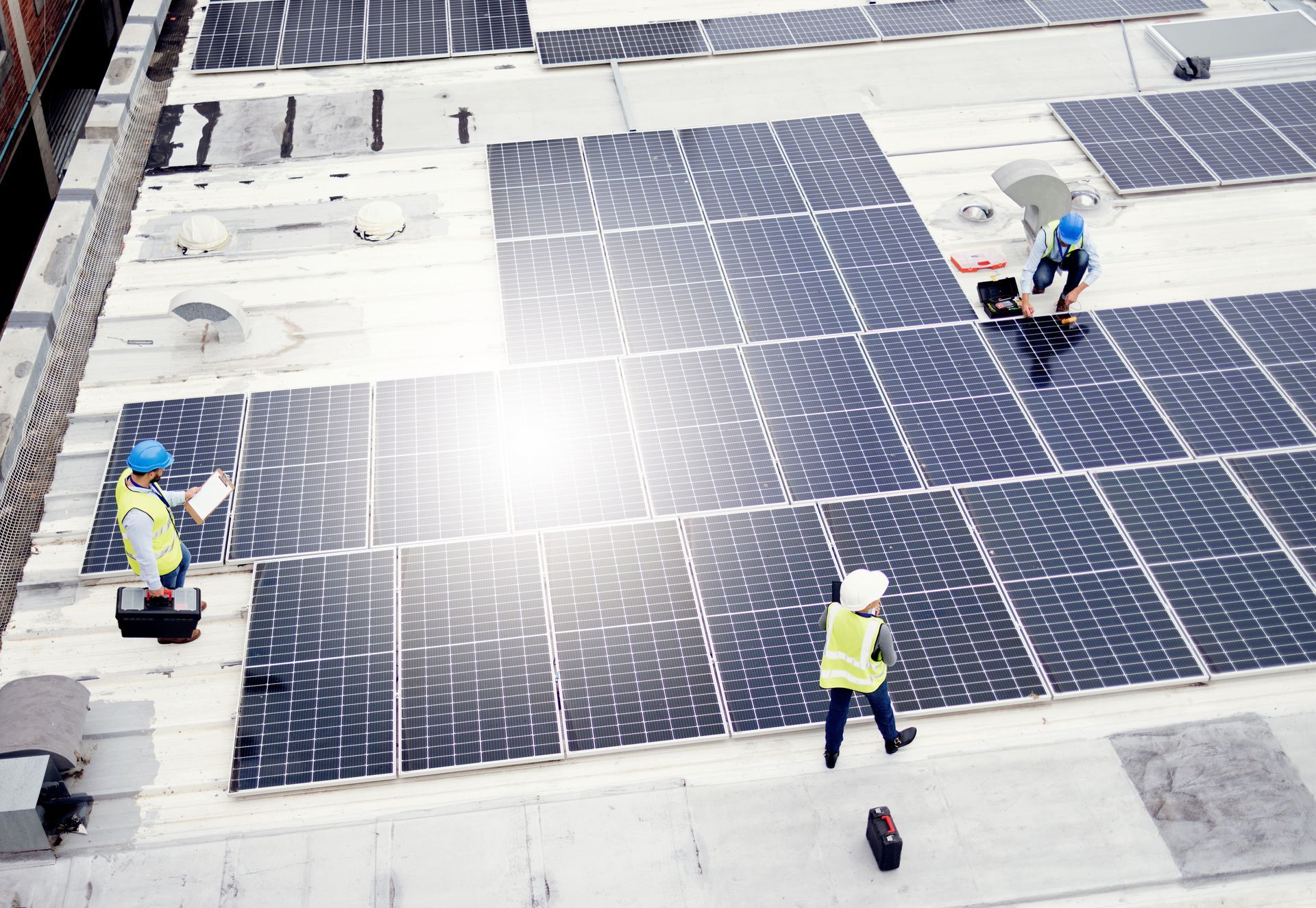 Workers installing solar panels on a rooftop.