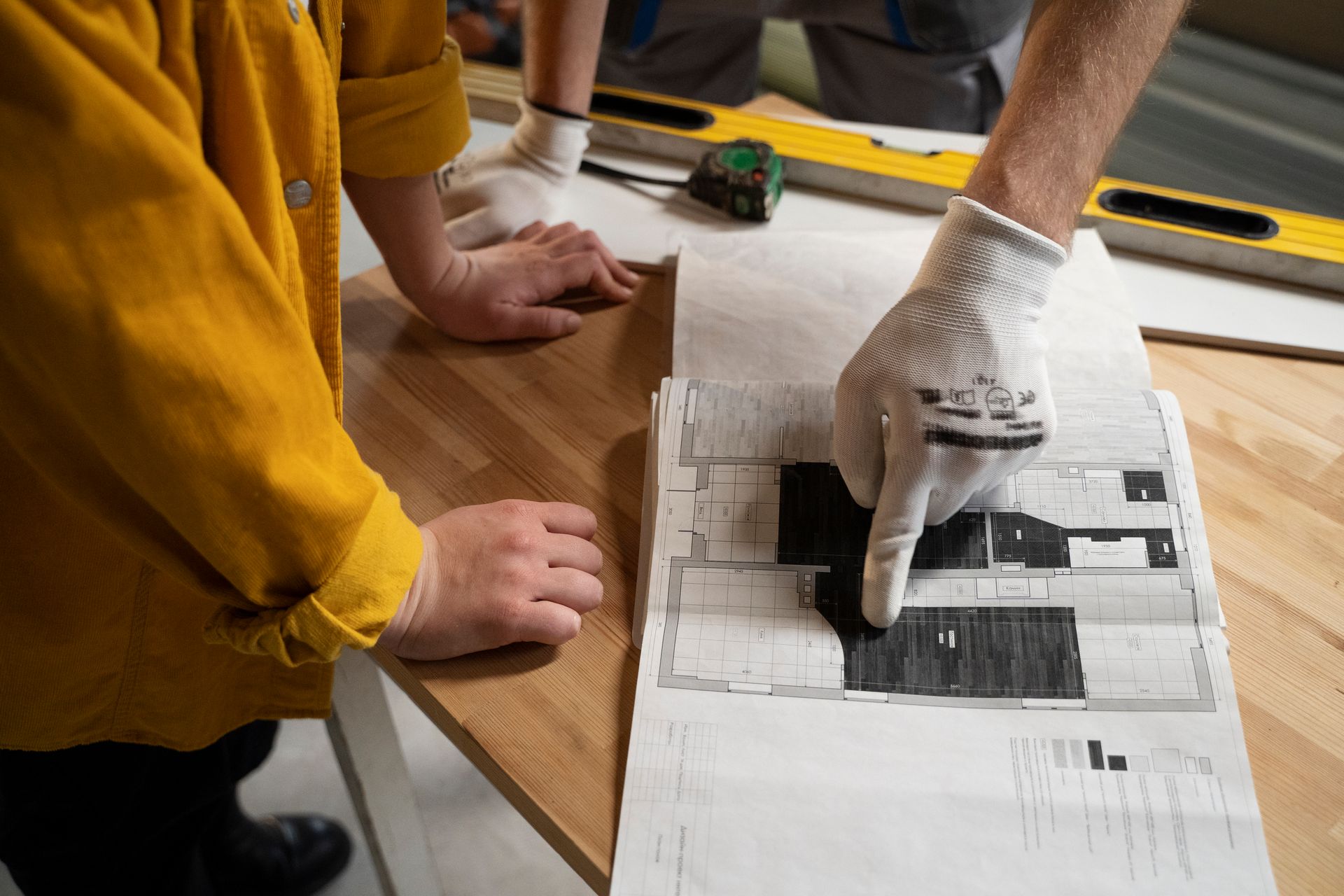 A man and a woman are looking at a blueprint of a house.