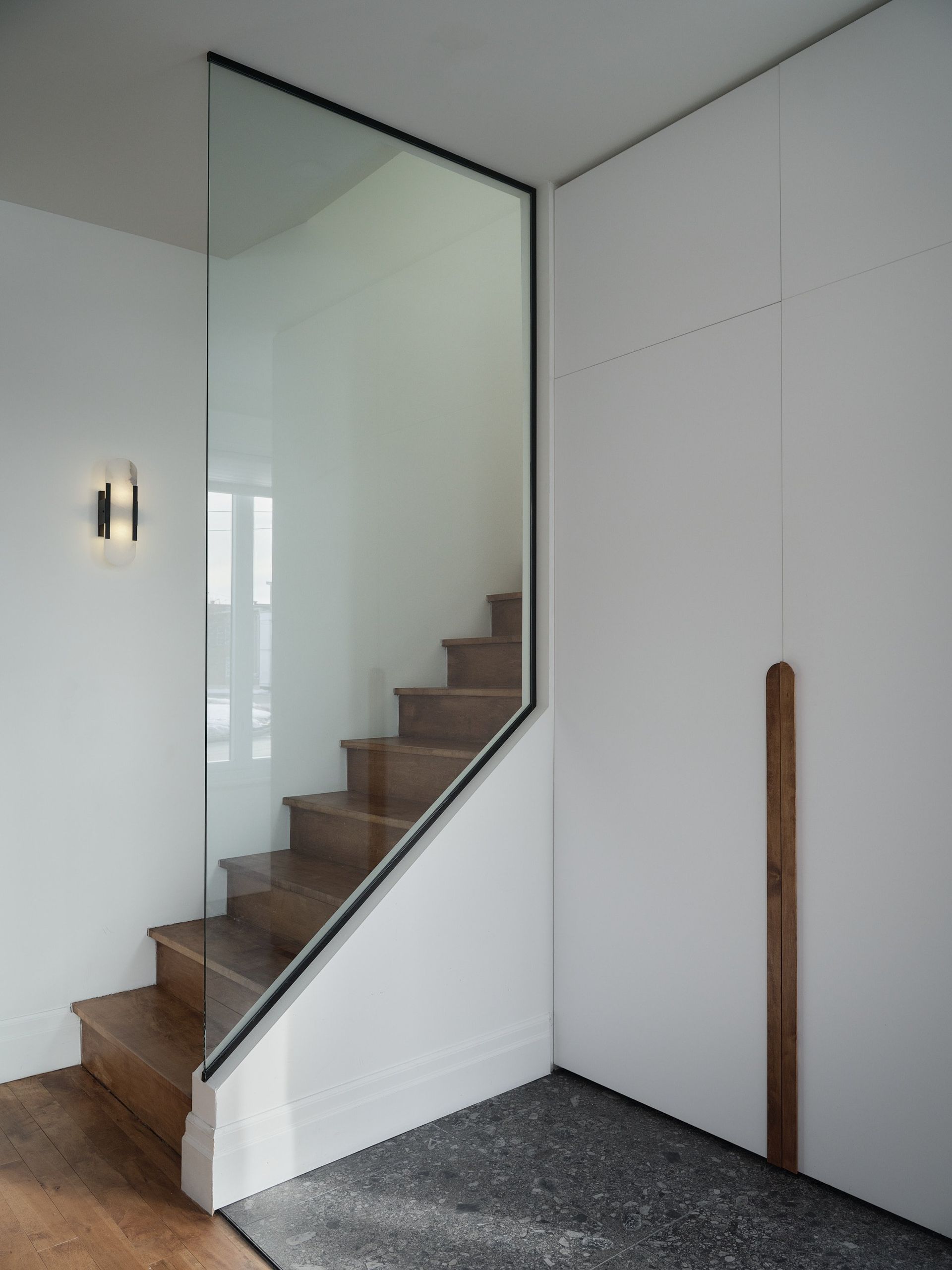 Un escalier avec une rampe en verre dans une pièce