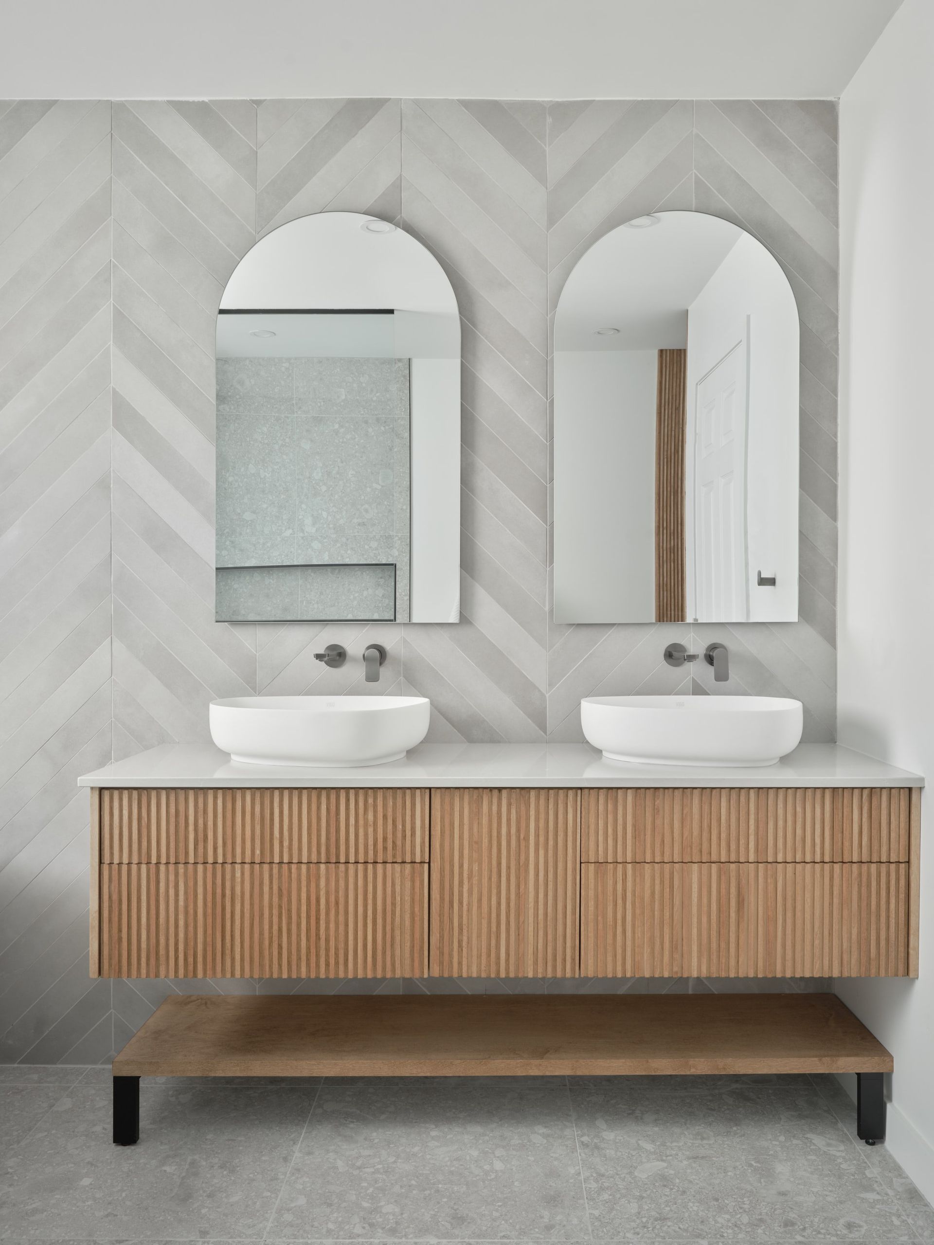 Une salle de bain avec deux lavabos et deux miroirs