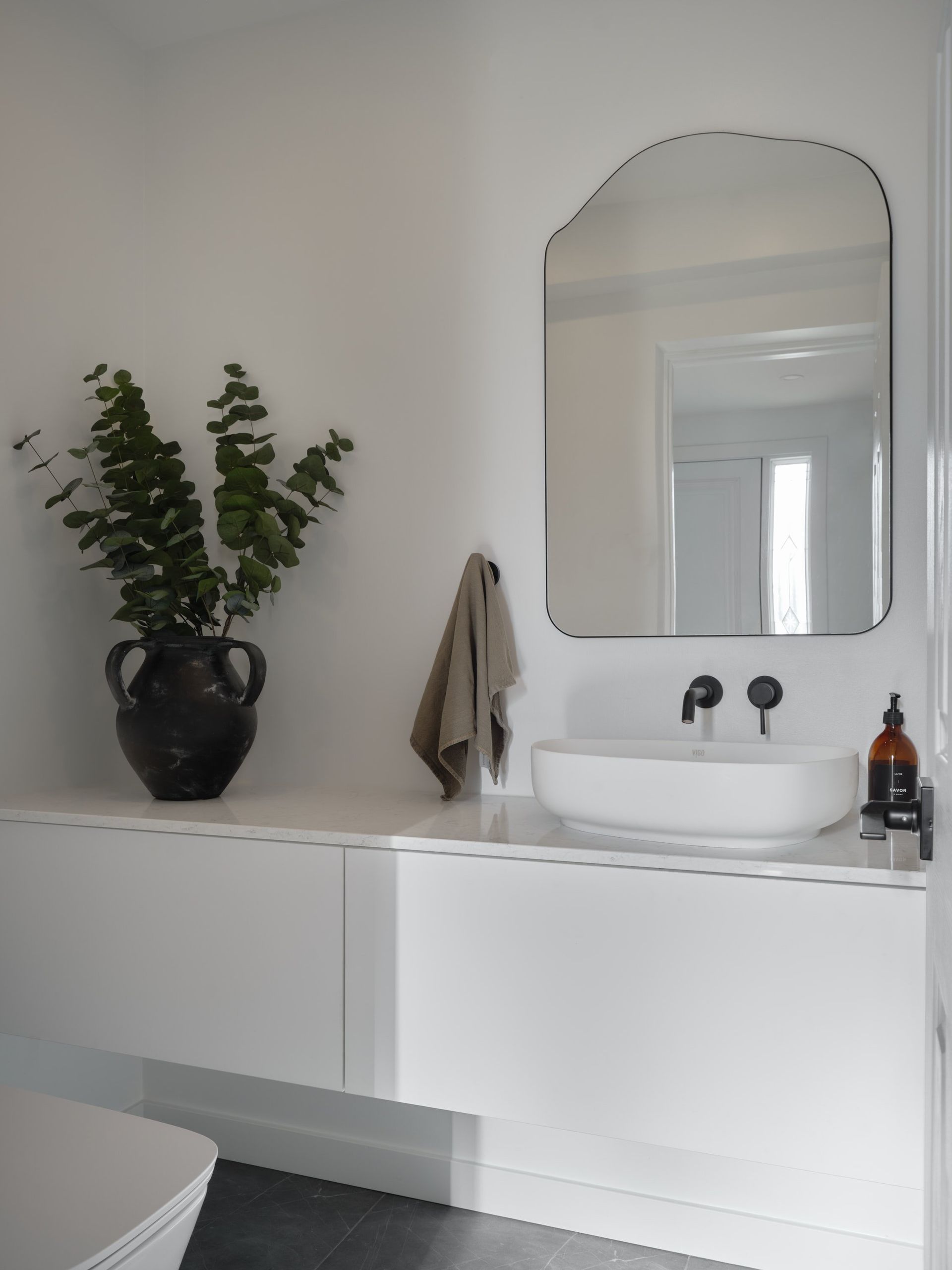 Une salle de bain avec lavabo , miroir et toilettes.