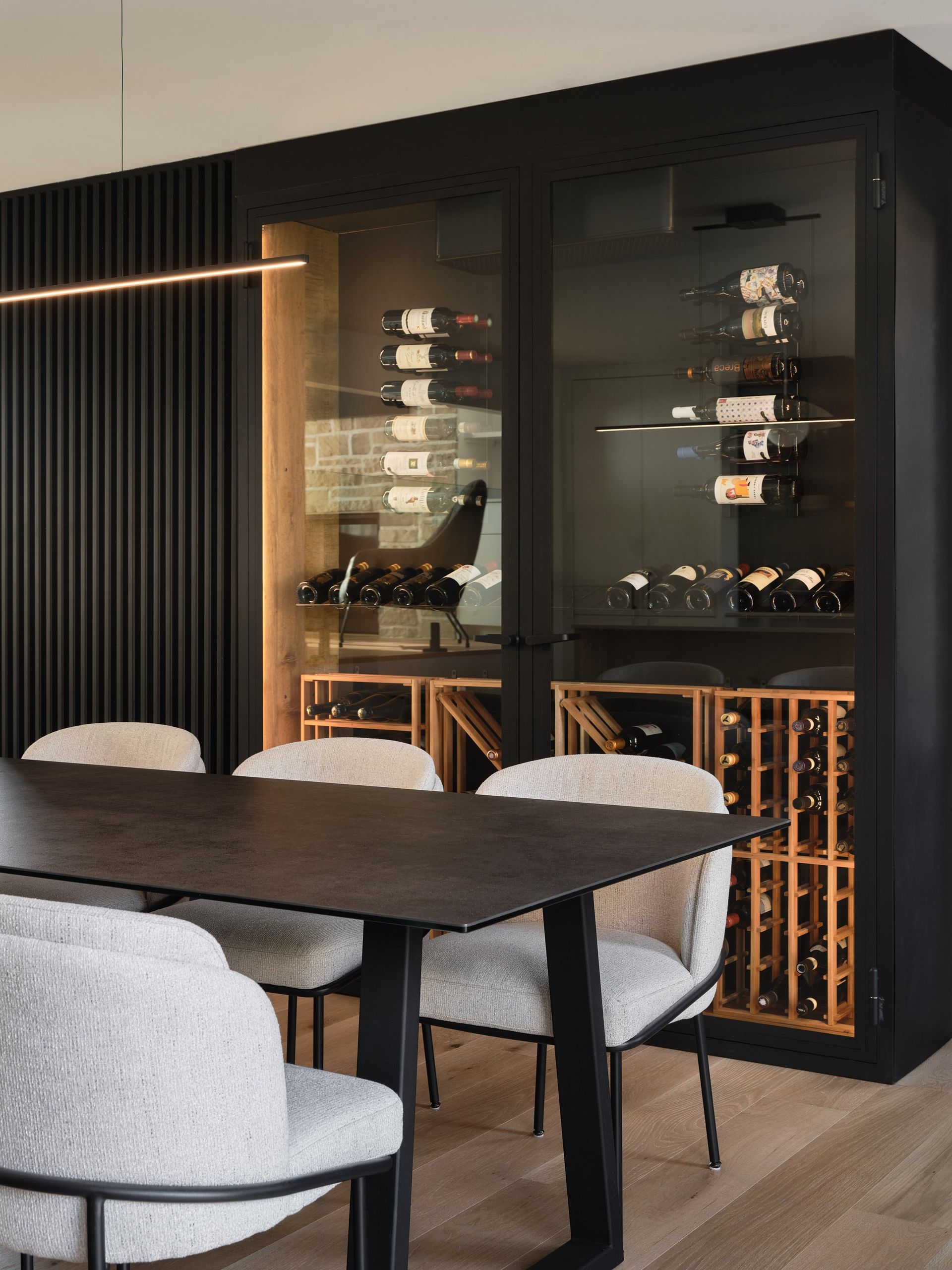 Une salle à manger avec table et chaises et une cave à vin.