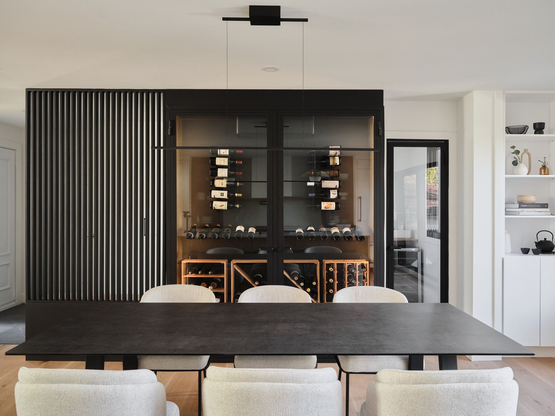 Une salle à manger avec table et chaises et une cave à vin