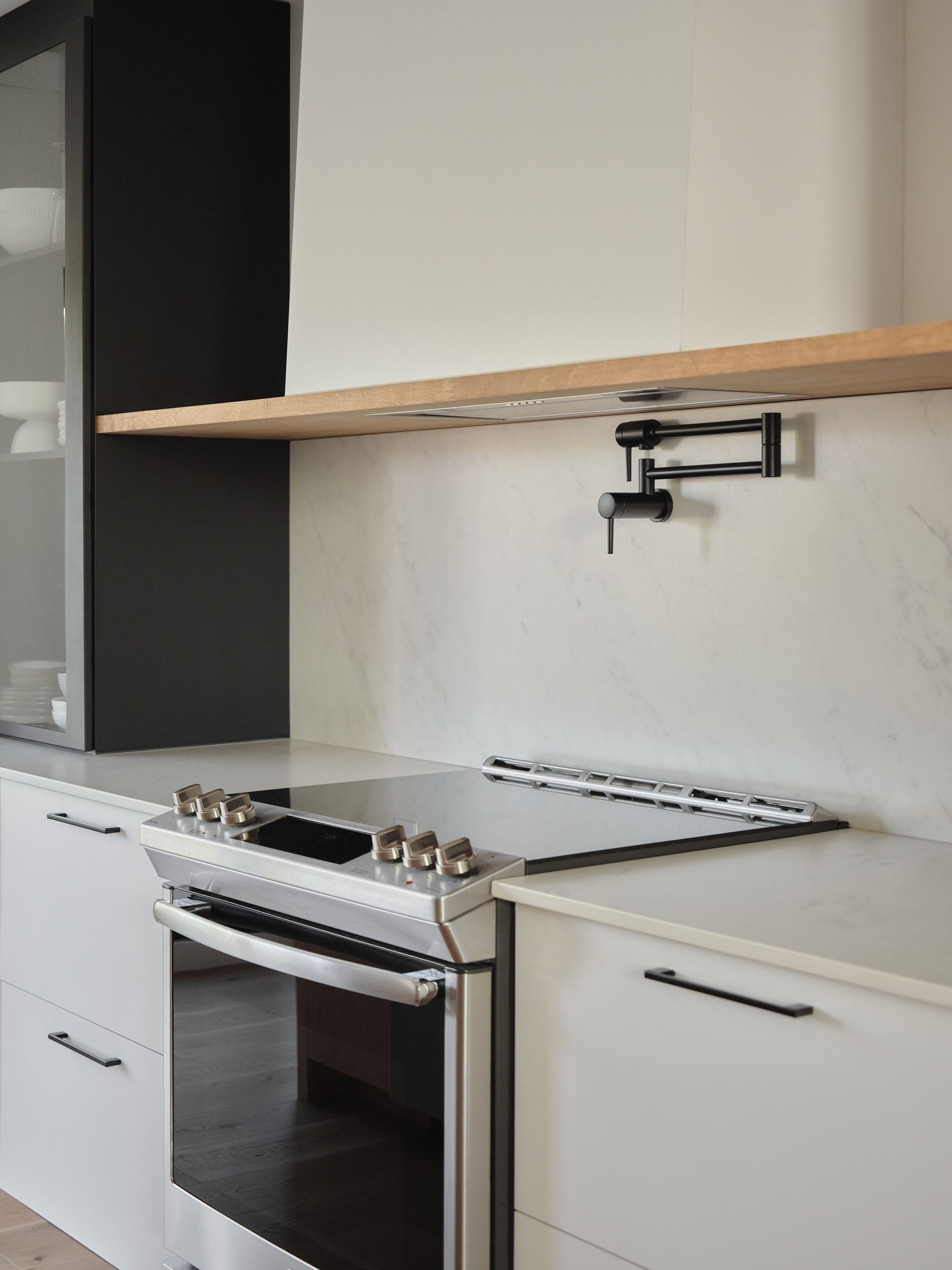 Une cuisine avec des armoires blanches et un four sur cuisinière