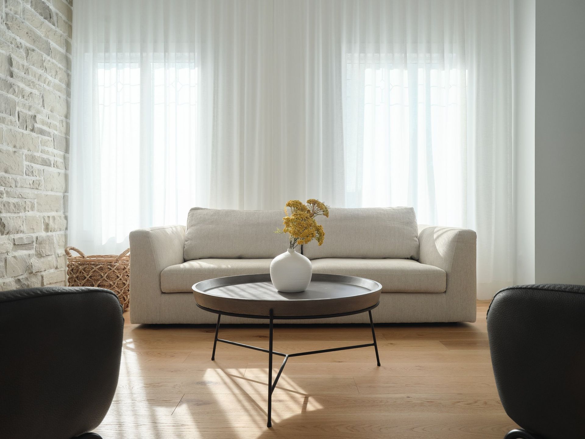 Un salon avec un canapé et une table basse avec un vase de fleurs dessus.