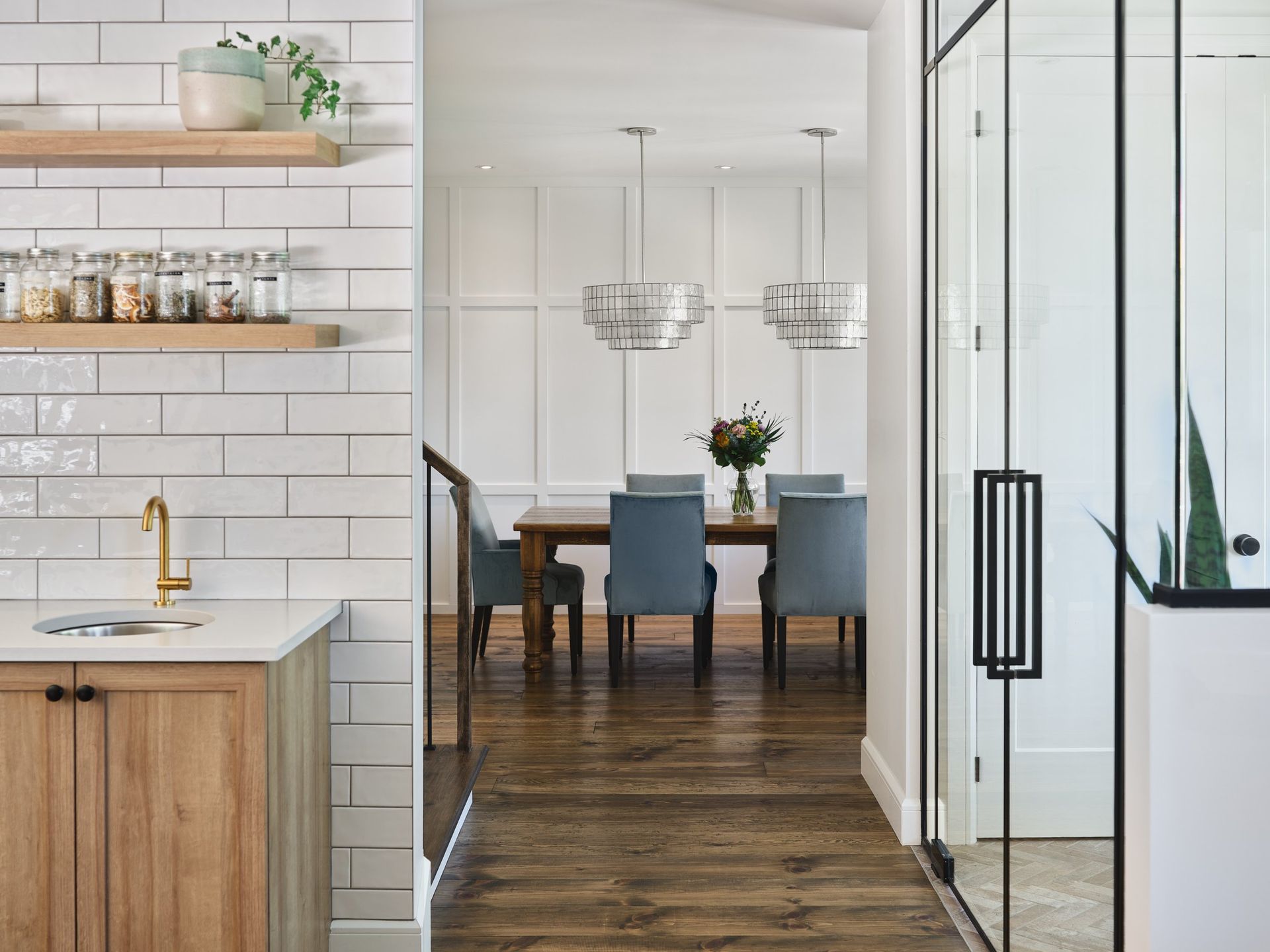 Une cuisine avec évier et une salle à manger avec table et chaises.