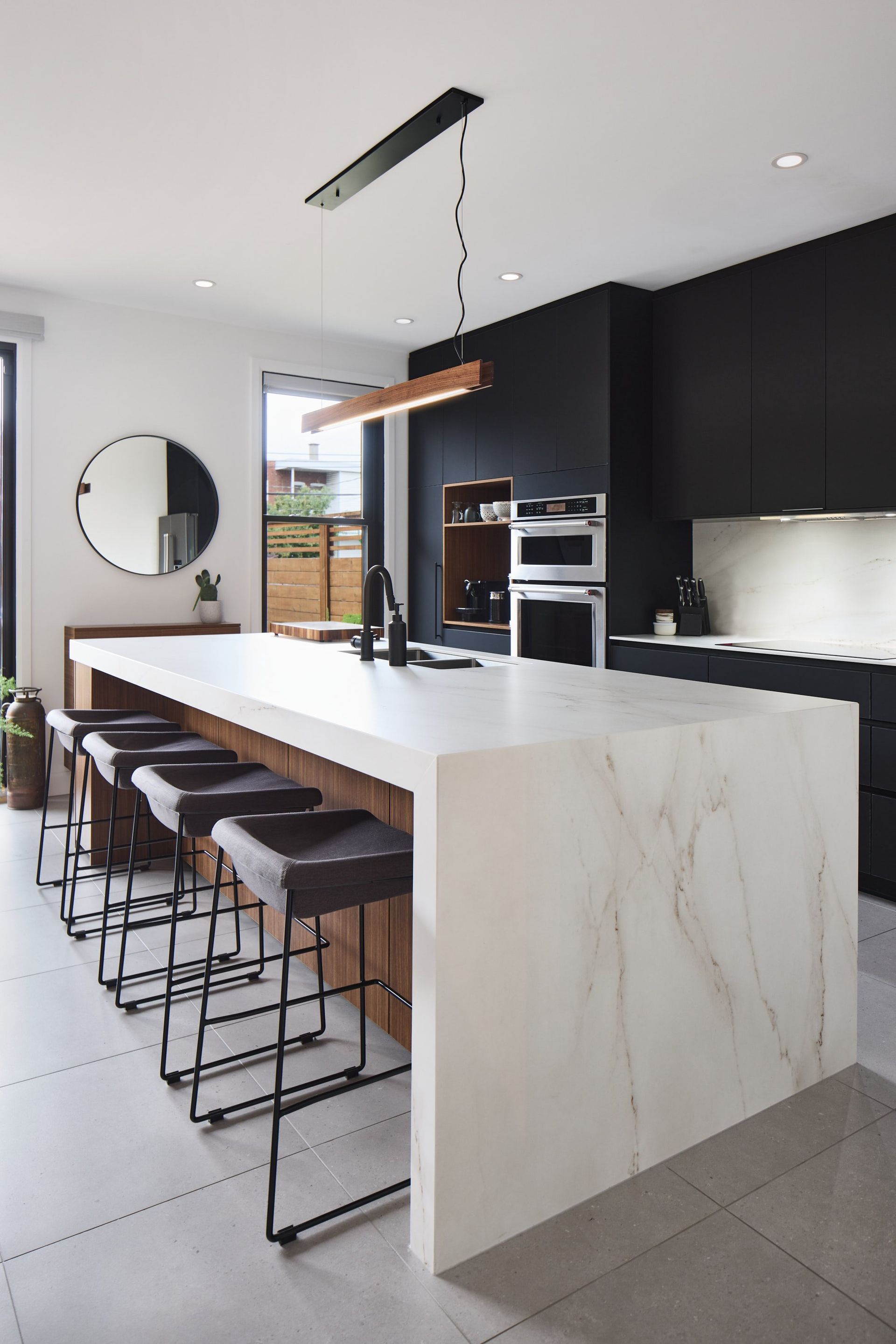 Une cuisine avec un grand îlot et des tabourets