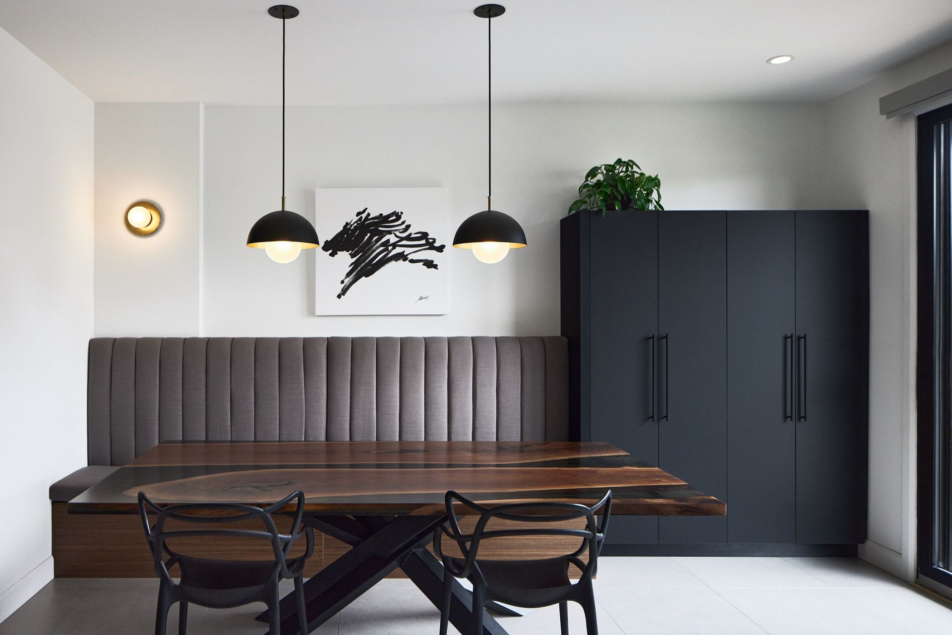 Une salle à manger avec une table et des chaises et un banc.