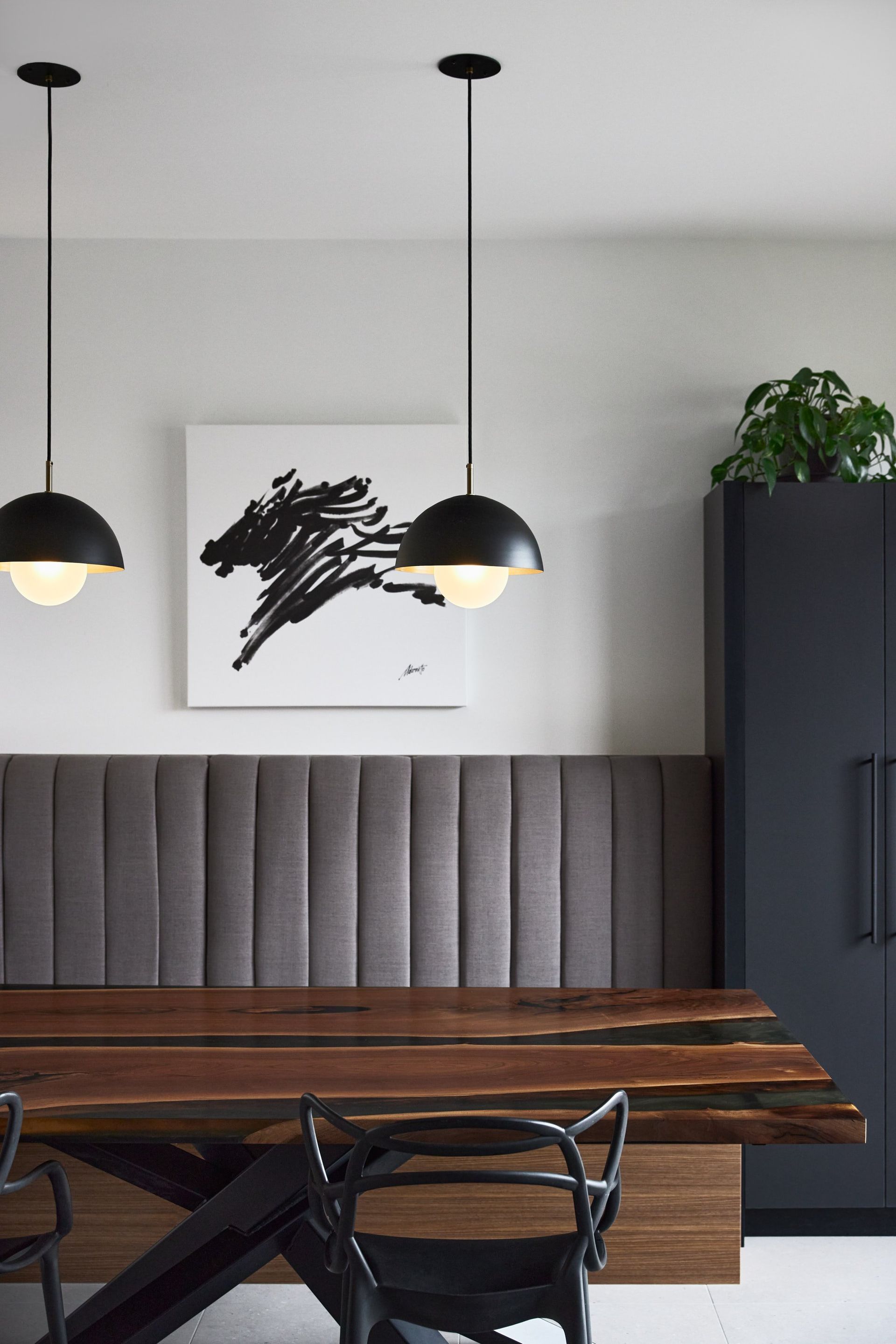Une salle à manger avec une table et des chaises en bois et un tableau au mur.
