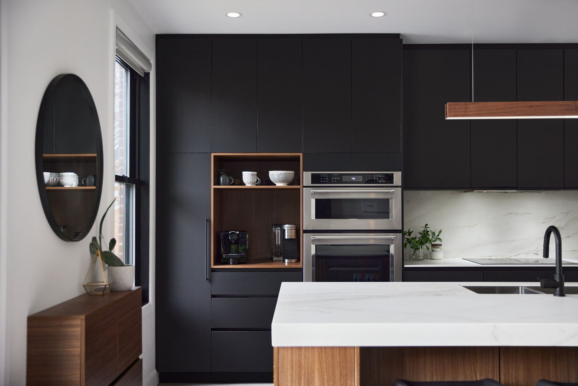 Une cuisine avec des armoires noires et un comptoir blanc