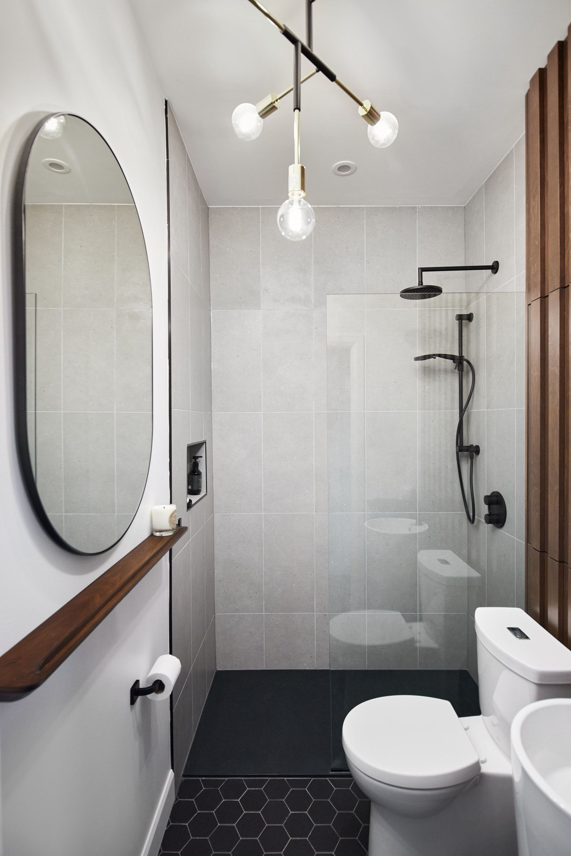 Une salle de bain avec WC, lavabo, miroir et douche.
