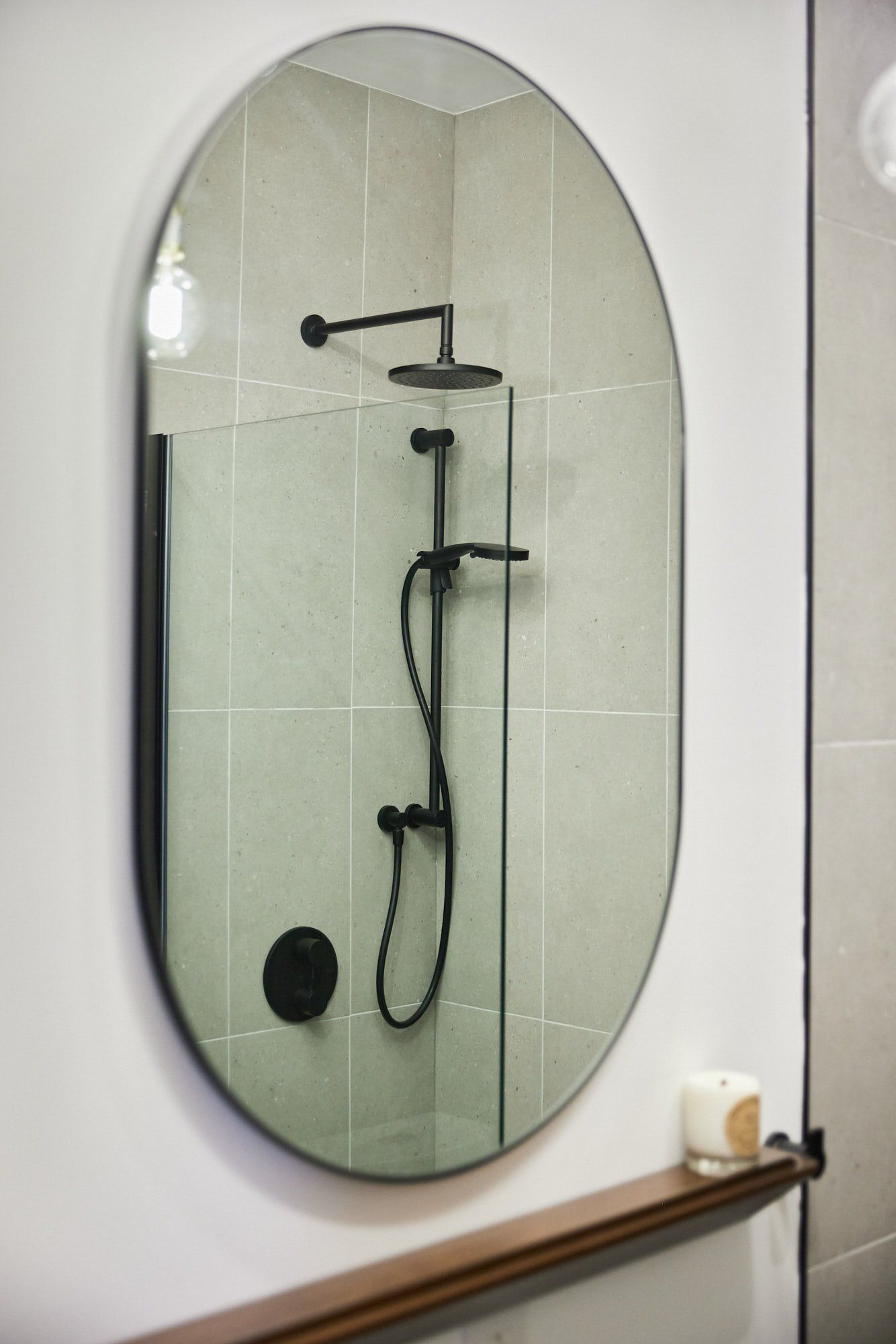 Une salle de bain avec douche et grand miroir