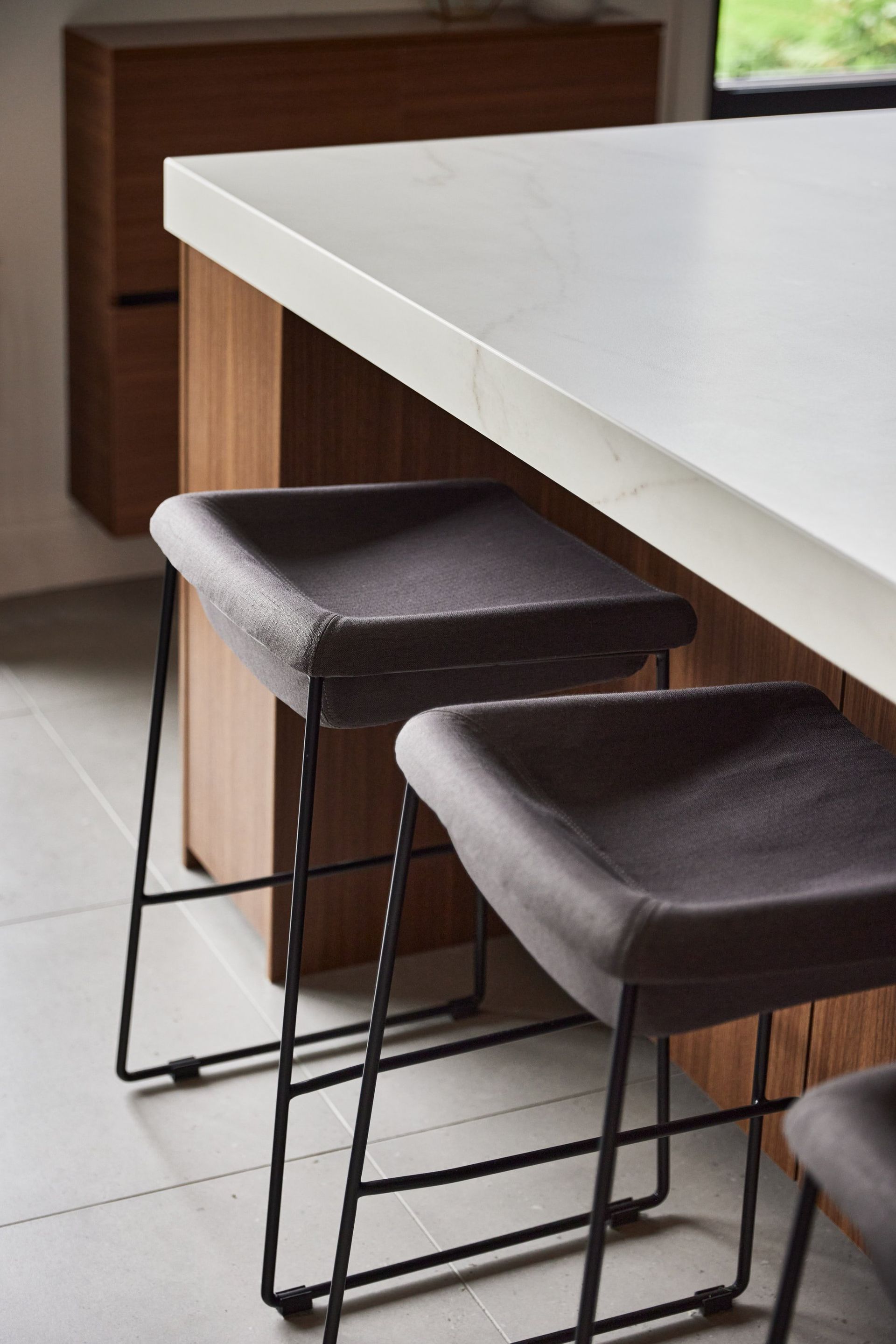 Deux tabourets de bar sont posés sous un comptoir dans une cuisine.