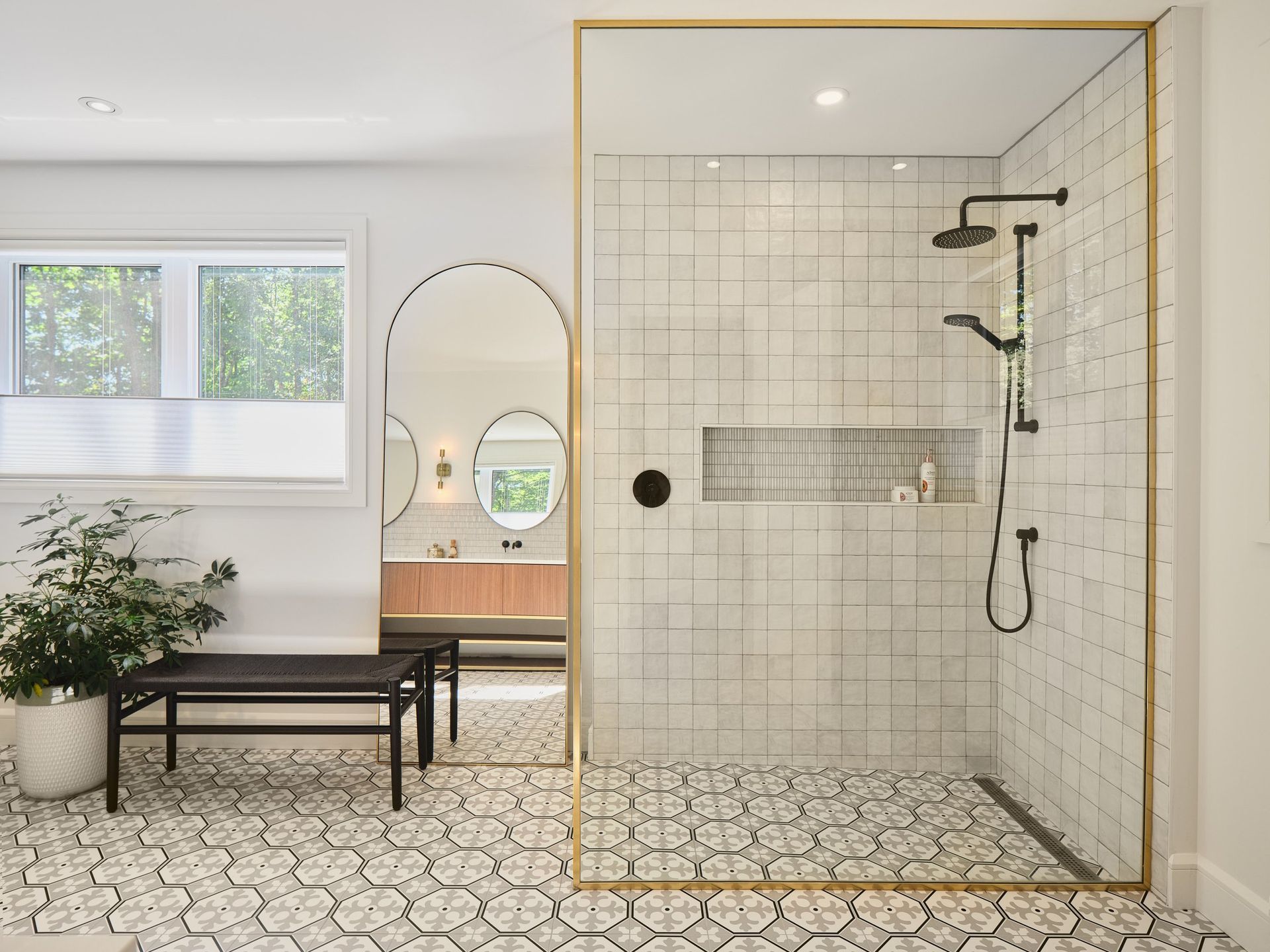 Une salle d'eau avec douche à l'italienne et banquette.