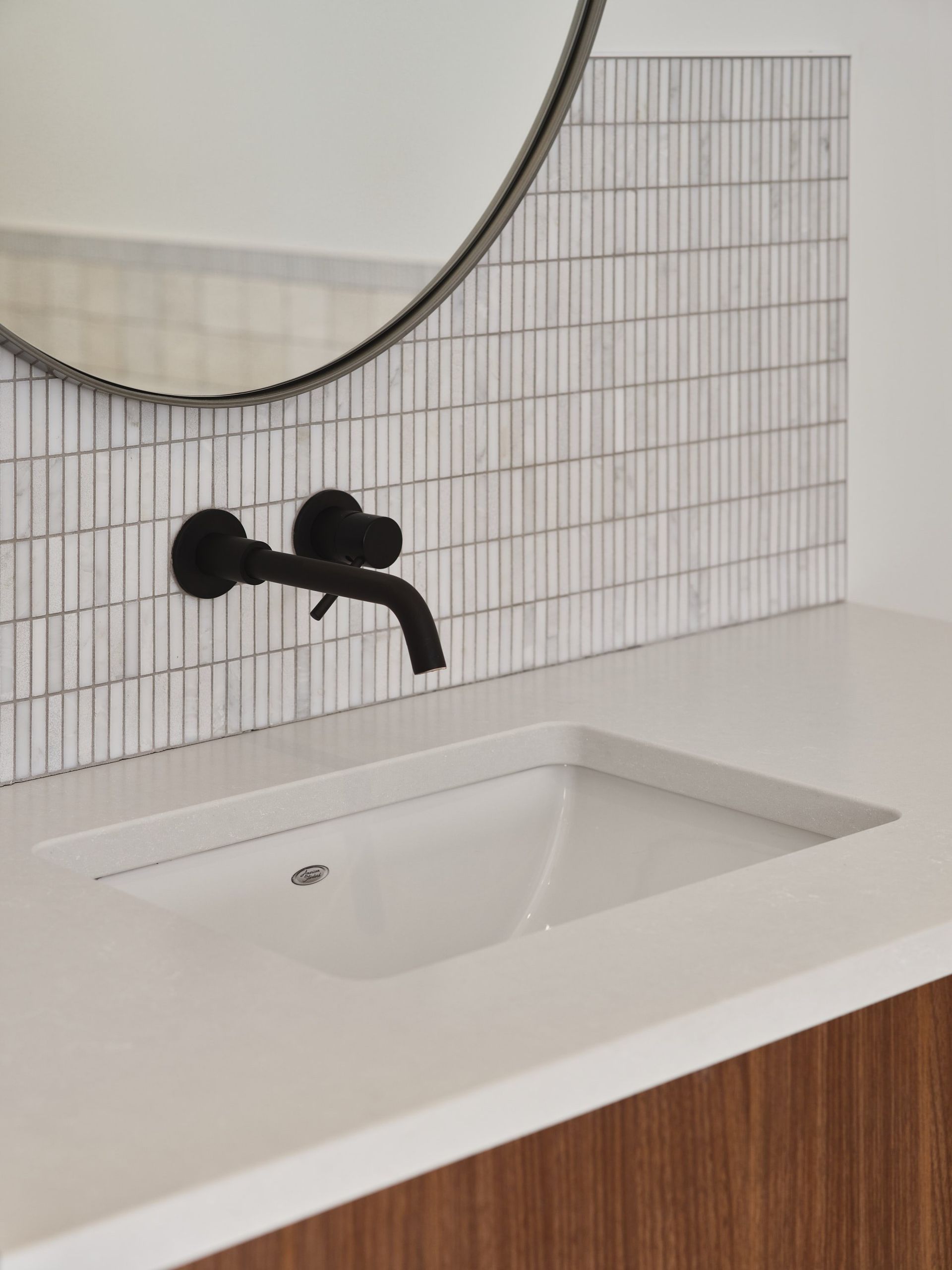 Un lavabo de salle de bain avec un robinet noir et un miroir.