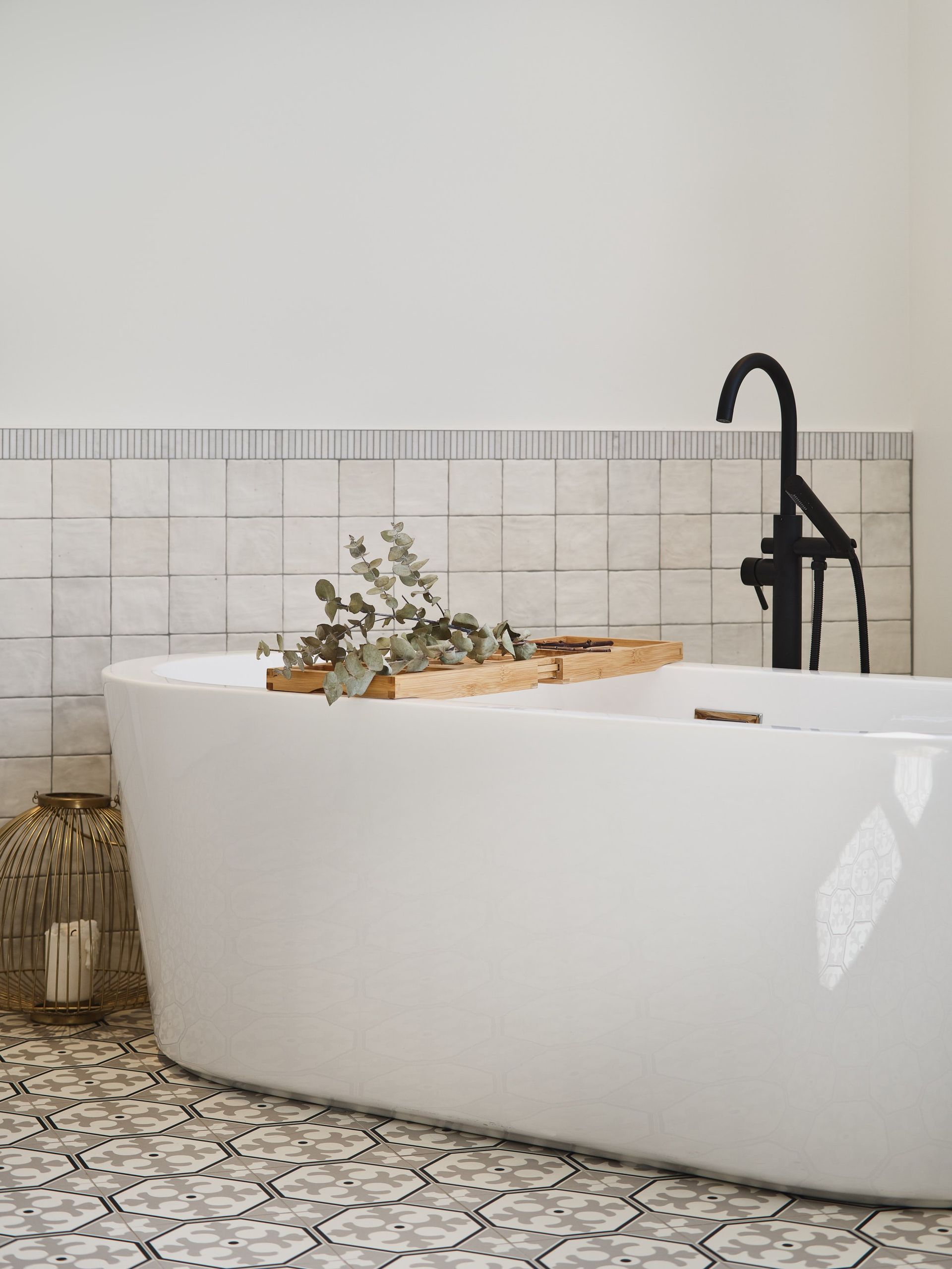 Une baignoire blanche avec un plateau en bois dessus dans une salle de bains.