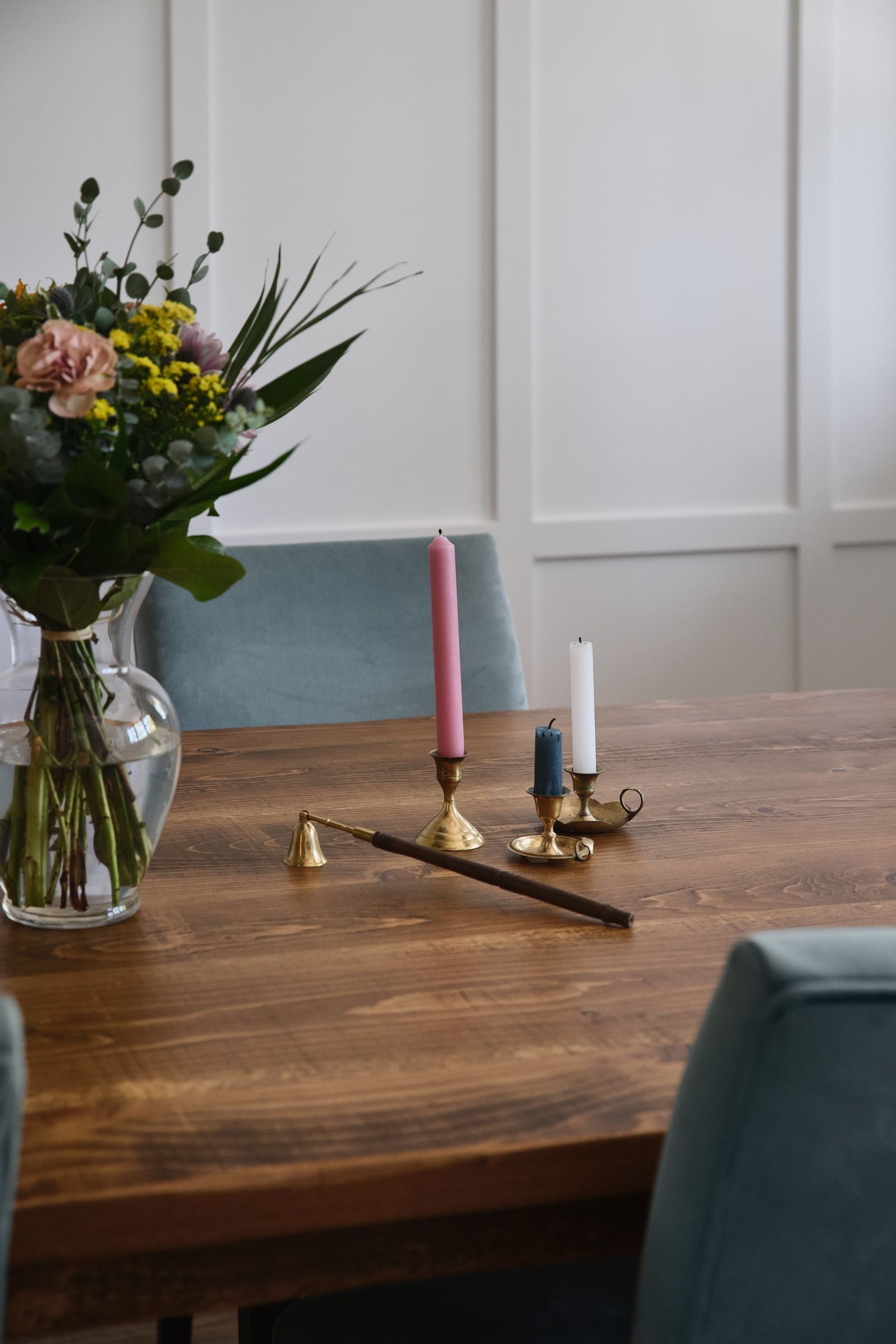 Une table en bois avec un vase de fleurs et des bougies dessus.