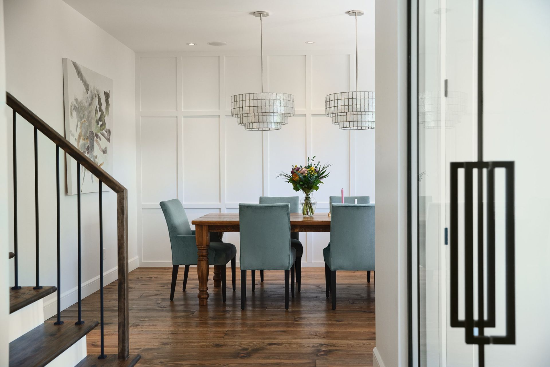 Une salle à manger avec une table et des chaises et un vase de fleurs sur la table.