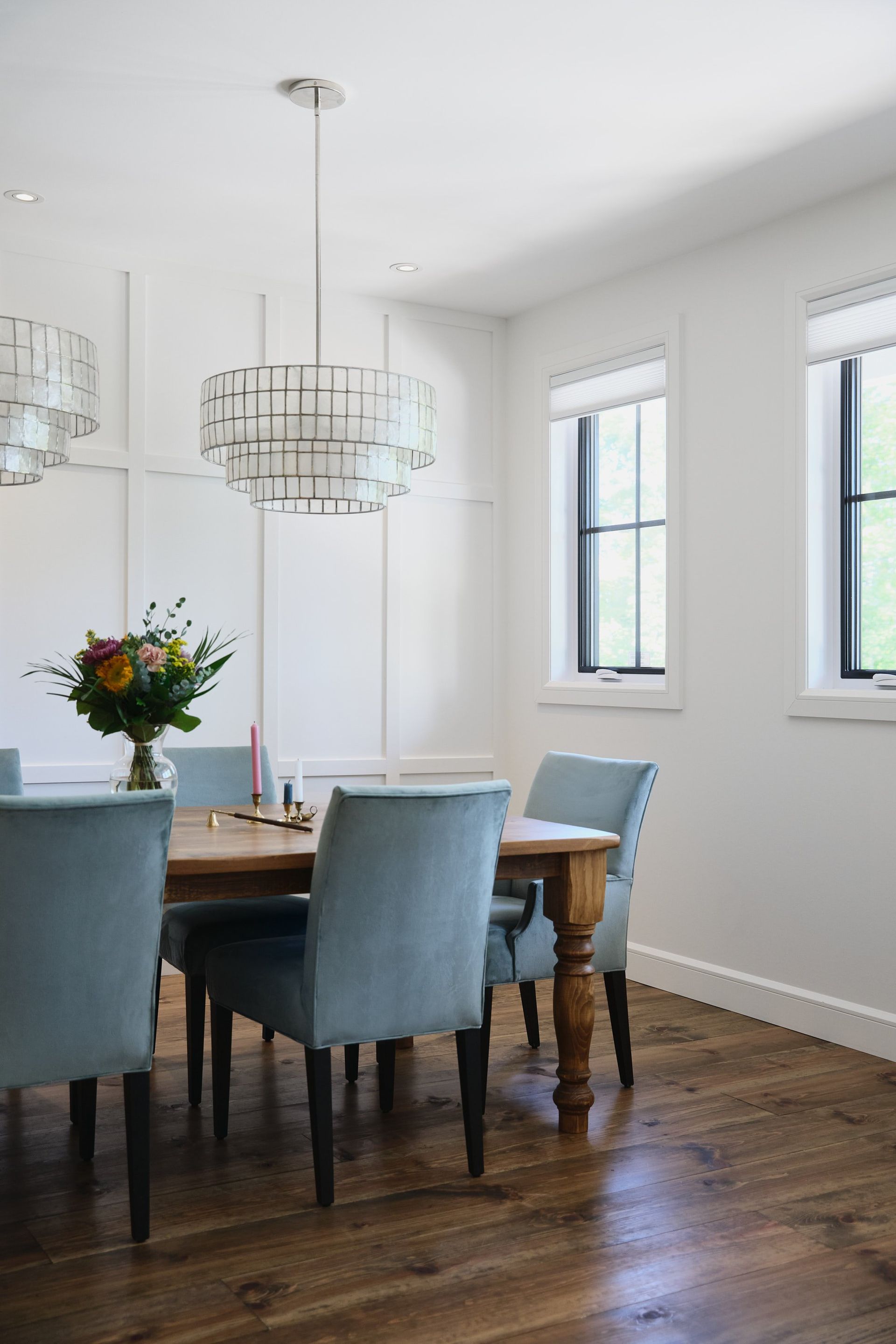 Une salle à manger avec une table et des chaises et un vase de fleurs sur la table.