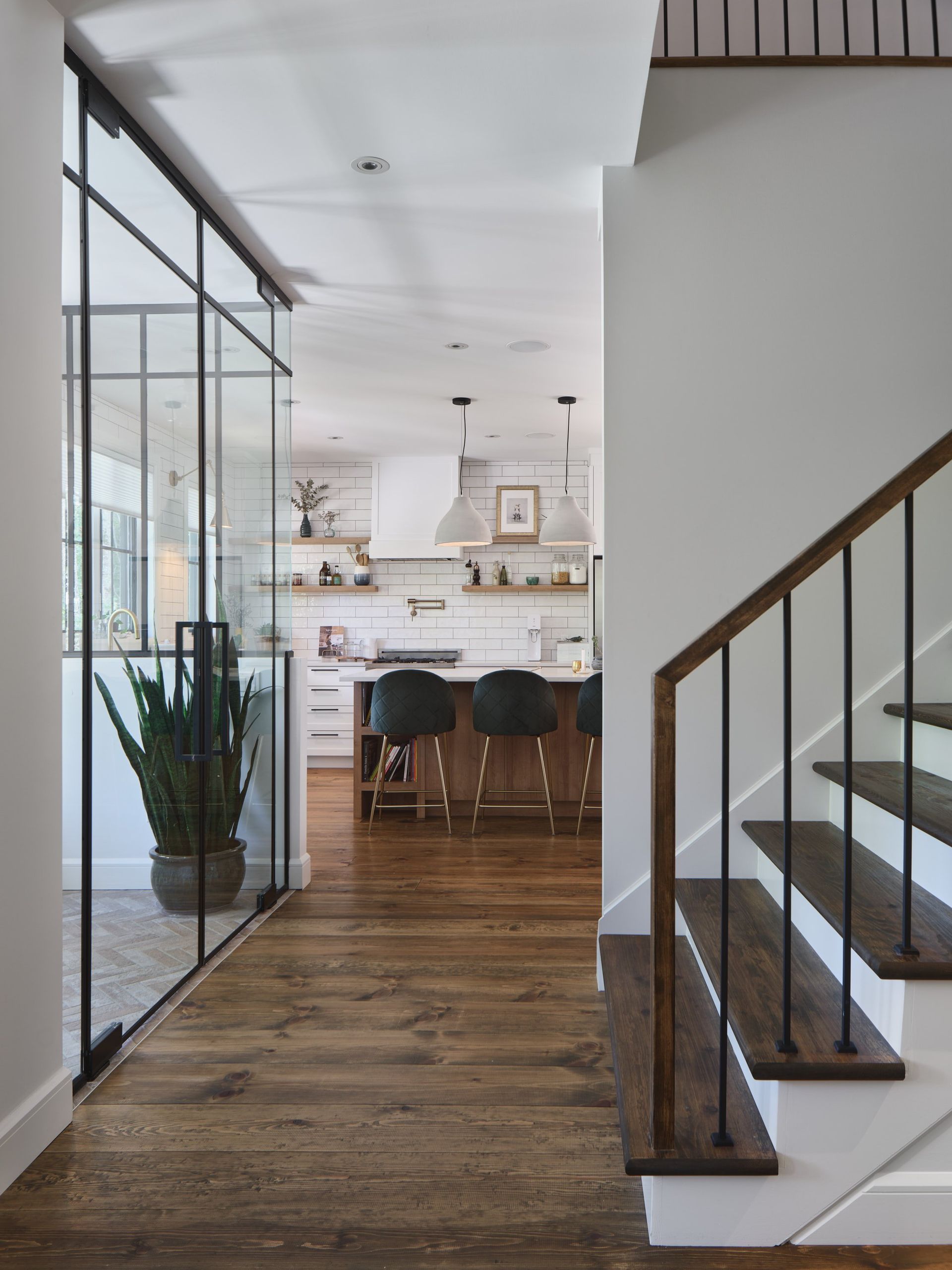 Un escalier menant à une cuisine avec une paroi vitrée