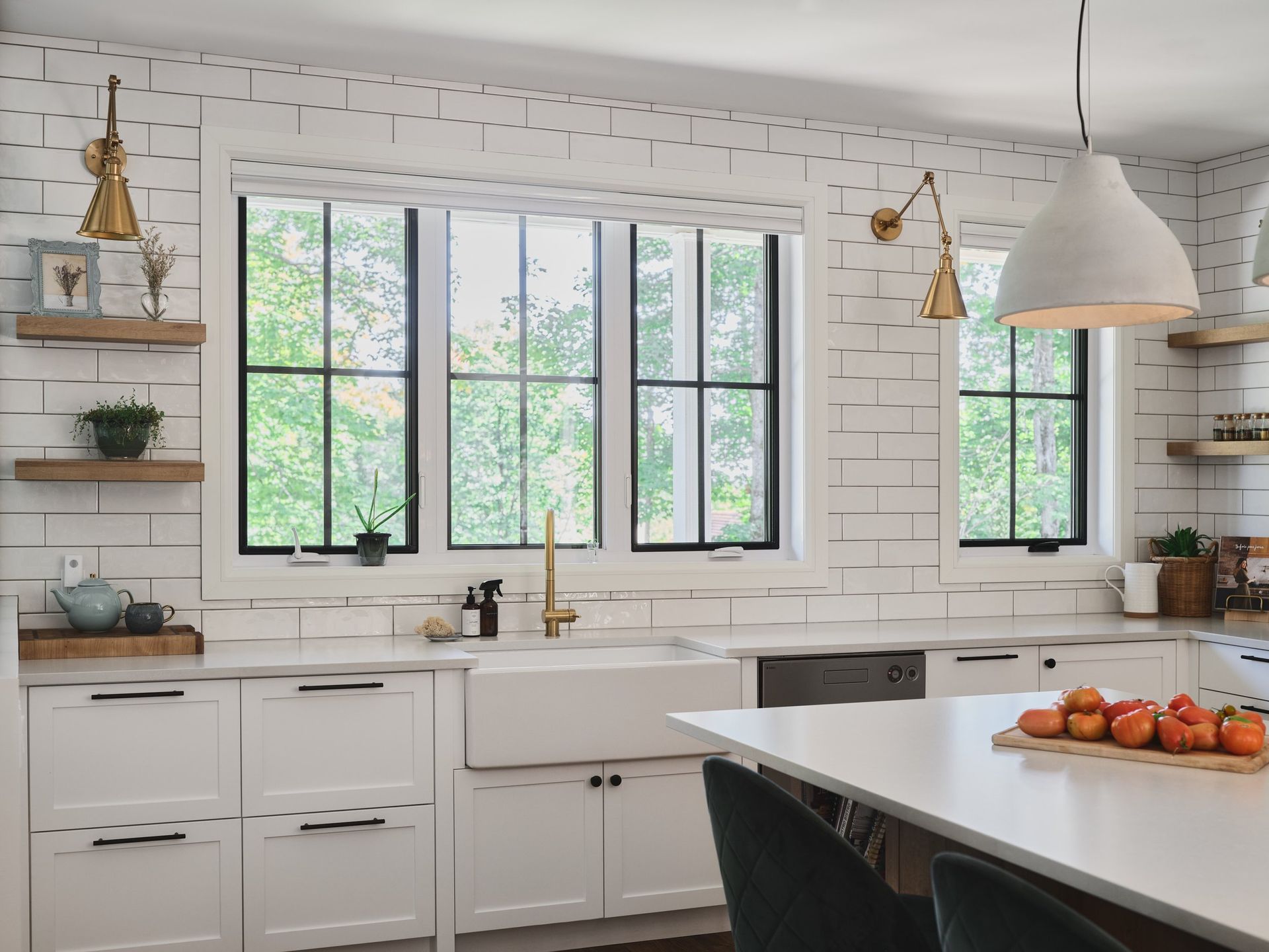 Une cuisine avec des armoires blanches, un évier et un grand îlot.