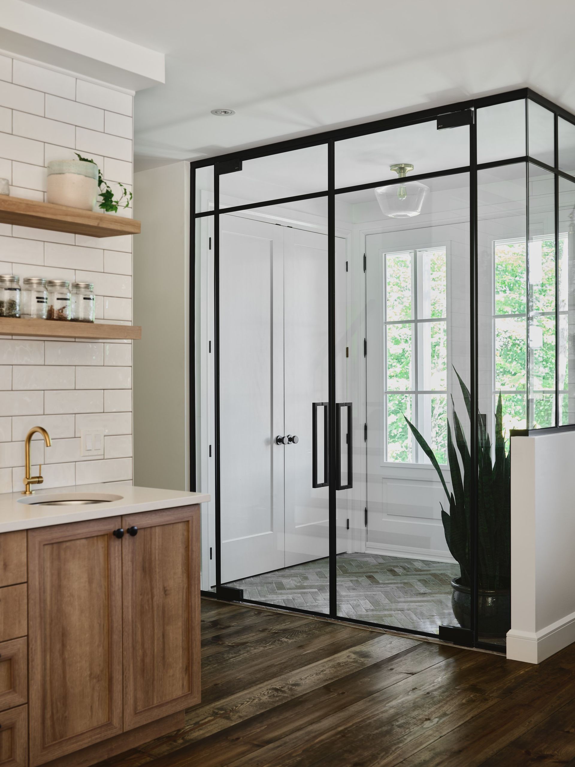 Une cuisine avec portes coulissantes en verre et armoires en bois