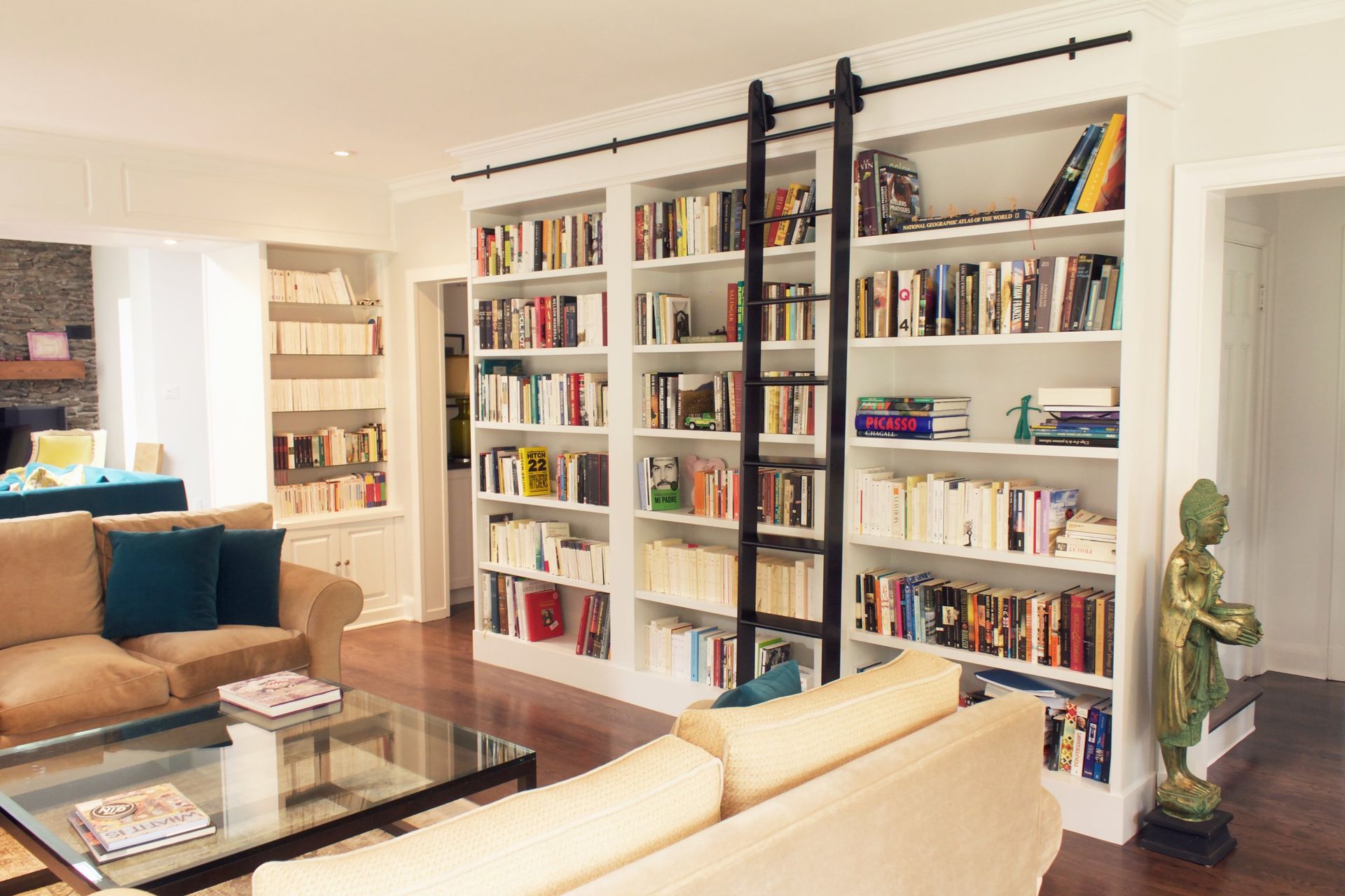 Un salon avec un canapé, une table basse et des étagères.