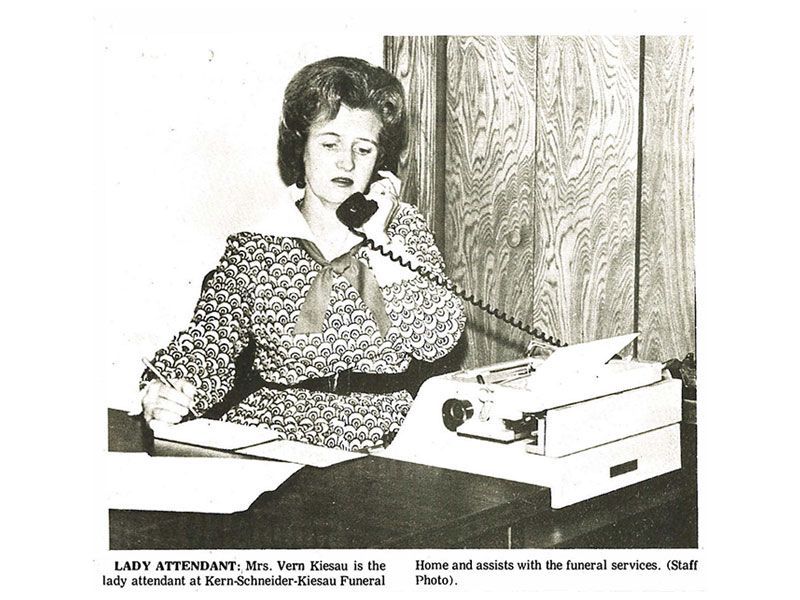 A black and white photo of a lady talking on a phone