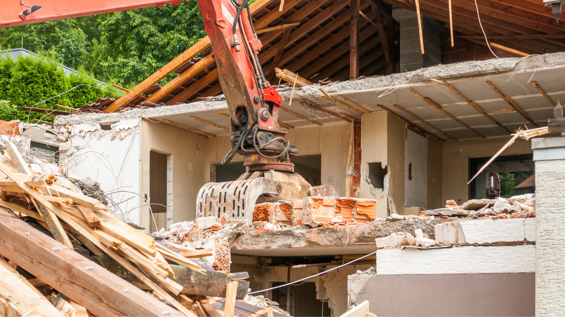 An excavator demolishes a building, surrounded by debris, daylight.