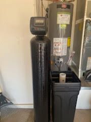 Water softener and heater with a black tank, salt container, and digital control panel.
