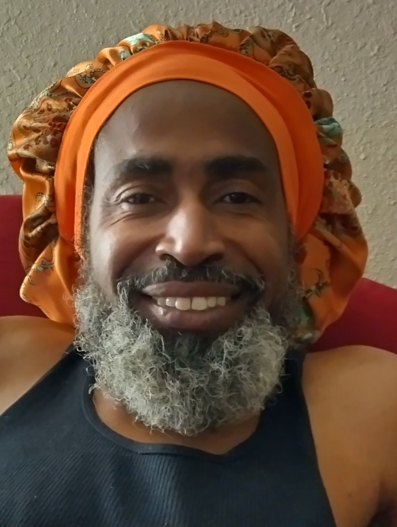 A man with a beard wearing an orange bonnet.