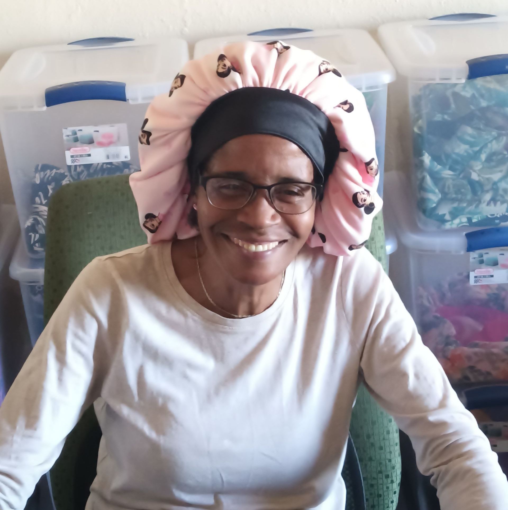 A woman wearing a pink bonnet with penguins on it