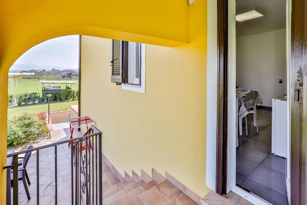 Un edificio giallo con un balcone e delle scale per accedervi.