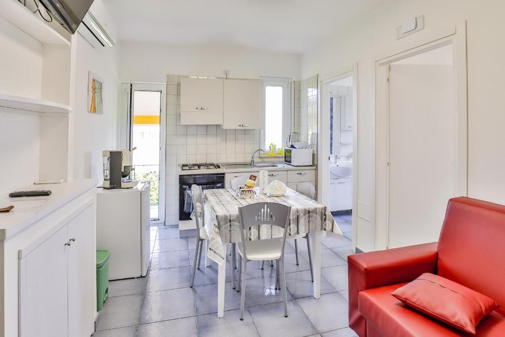 Un soggiorno con un divano rosso, un tavolo e delle sedie