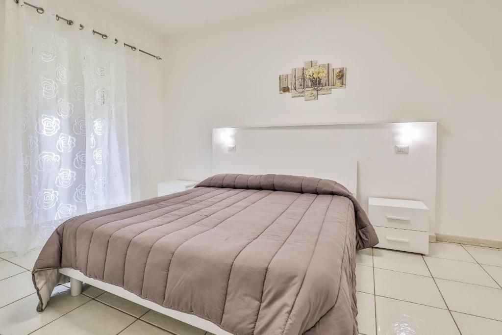 Una camera da letto con un letto, un comodino e una finestra.