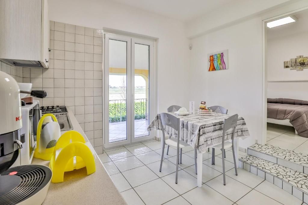 Una cucina con tavolo, sedie e ventilatore.