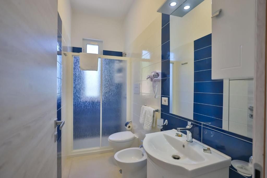 Un bagno con lavandino, WC e doccia