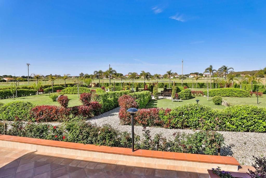 Una vista di un giardino da un balcone con un cielo azzurro sullo sfondo.