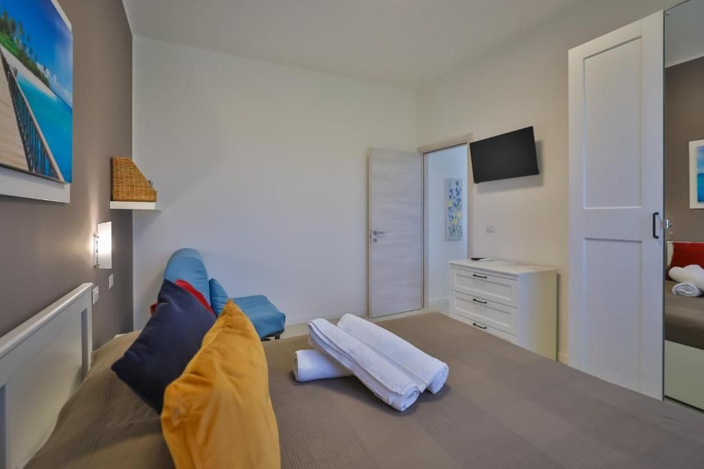 Una camera da letto con un letto, una cassettiera, una sedia e una televisione.