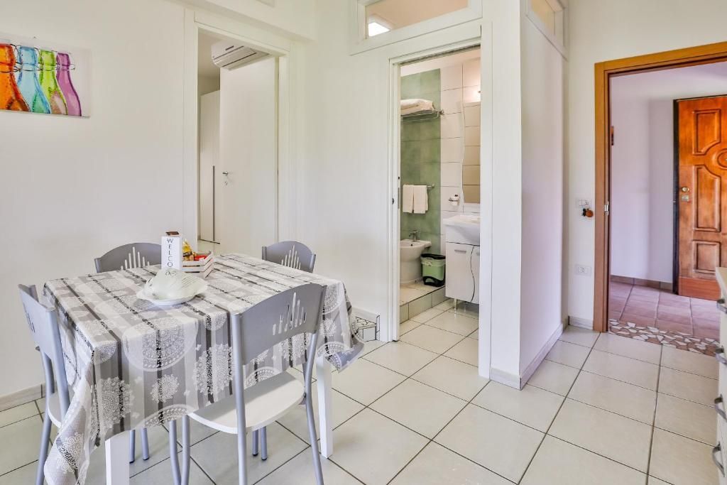 Una sala da pranzo con tavolo e sedie e un bagno sullo sfondo.