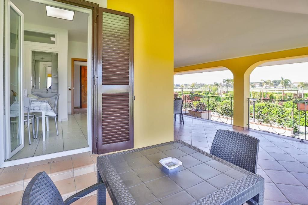 C'è un tavolo e delle sedie sul balcone di una casa.