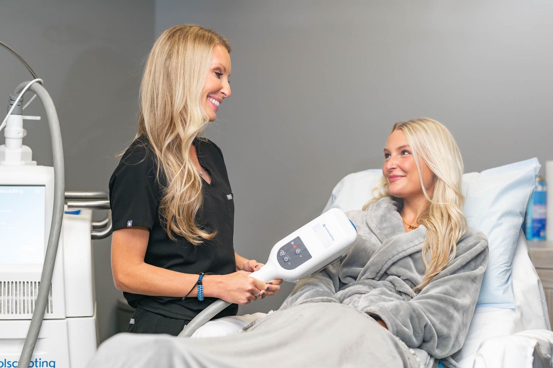 A woman is laying in a hospital bed talking to a nurse